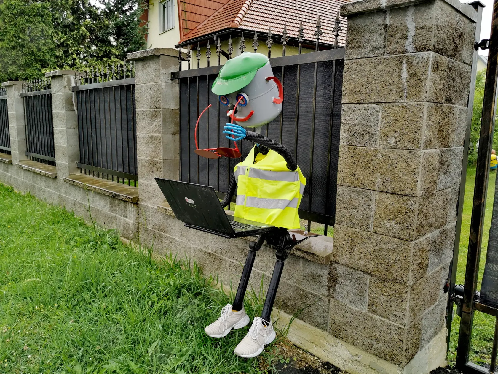 Jeden policajt sedí na múriku, v ruke drží okuliare a zapisuje priestupky do počítača.