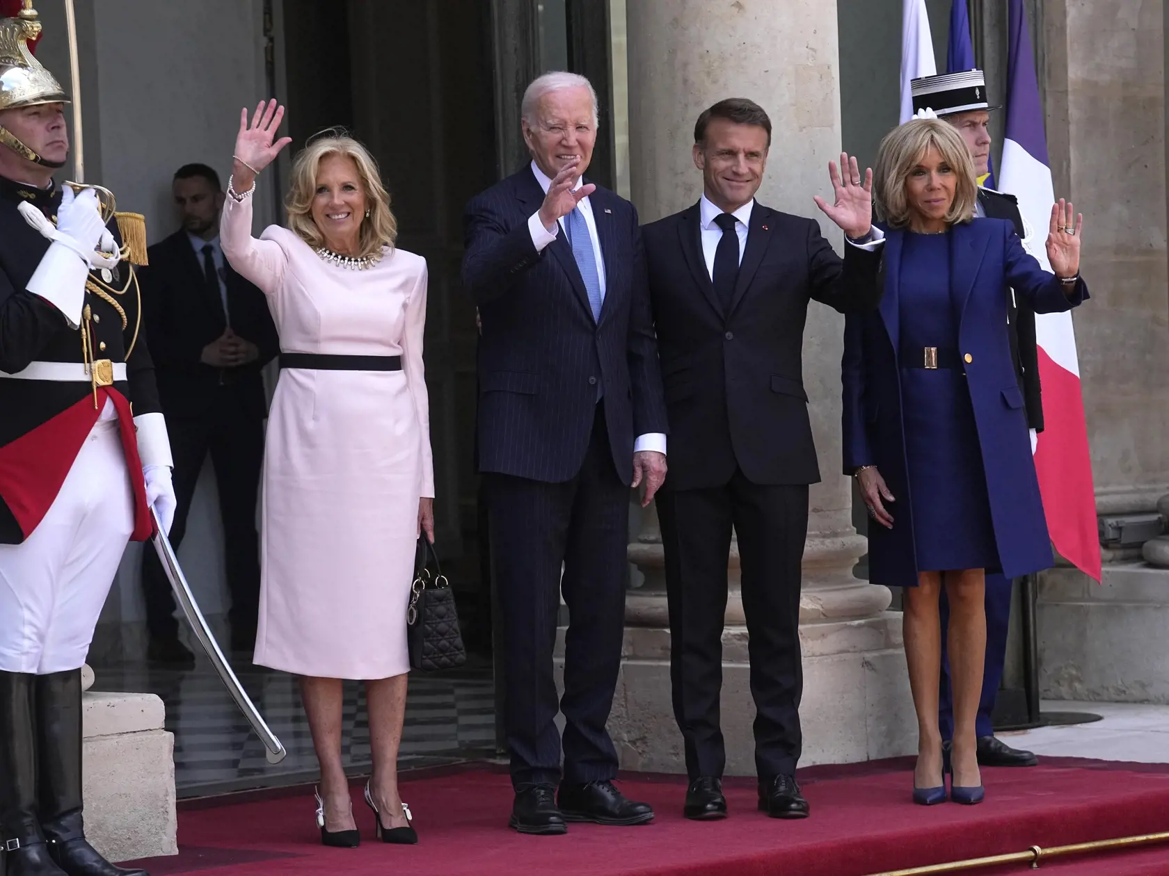 Americký prezident Joe Biden (uprostred), jeho manželka Jill Bidenová (tretia zľava), francúzsky prezident Emmanuel Macron (tretí sprava) a jeho manželka Brigitte Macronová (druhá vpravo) mávajú pred Elyzejským palácom v Paríži v sobotu 8. júna 2024. Americký prezident Joe Biden s manželkou v stredu pricestovali na päťdňovú návštevu Francúzska, kde sa v Normandii zúčastnili na oslavách 80. výročia vylodenia spojencov. Do Francúzska pricestoval počas volebného roka.