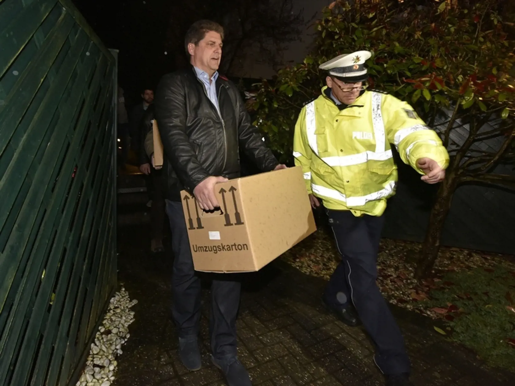 Polícia vynáša z domu kopilota a jeho rodiny plné škatule.