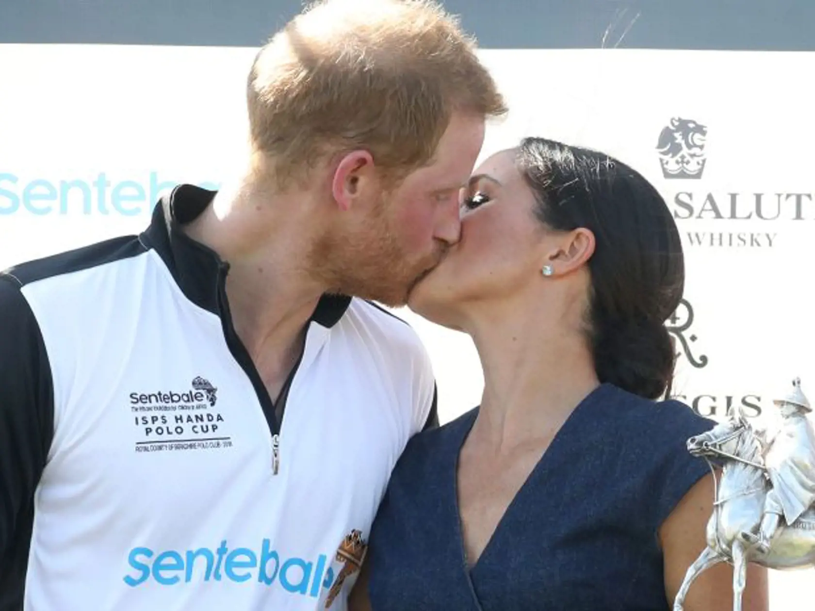 WINDSOR, ENGLAND - JULY 26:  Meghan Duchess of Sussex and Prince Harry Duke of Sussex kiss after posing with the trophy after the Sentebale Polo 2018 held at the Royal County of Berkshire Polo Club on July 26, 2018 in Windsor, England.  (Photo by Chris Jackson/Getty Images)