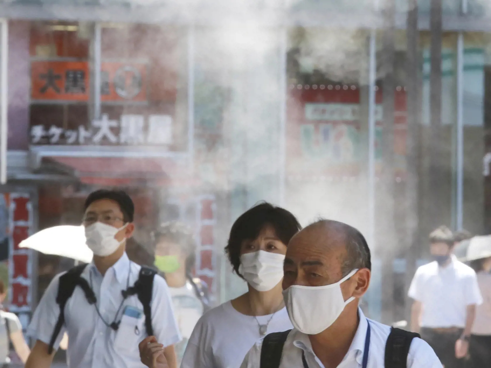 KK26 Tokio - Na snímke ľudia s ochrannými rúškami kráčajú pod vodnou sprchou 5. augusta 2021 v Tokiu. V stredu padol v Japonsku rekord v počte denného nárastu nakazených ľudí na koronavírus. Japonské médiá uviedli, že počet nakazených za jeden deň prekročil 14.000 prípadov, čo je zatiaľ maximum. V hlavnom meste Tokiu zaznamenali rekordných 4166 prípadov napriek tomu, že od 12. júla v metropole platí núdzový stav. FOTO TASR/AP
People wearing face masks to protect against the spread of the coronav