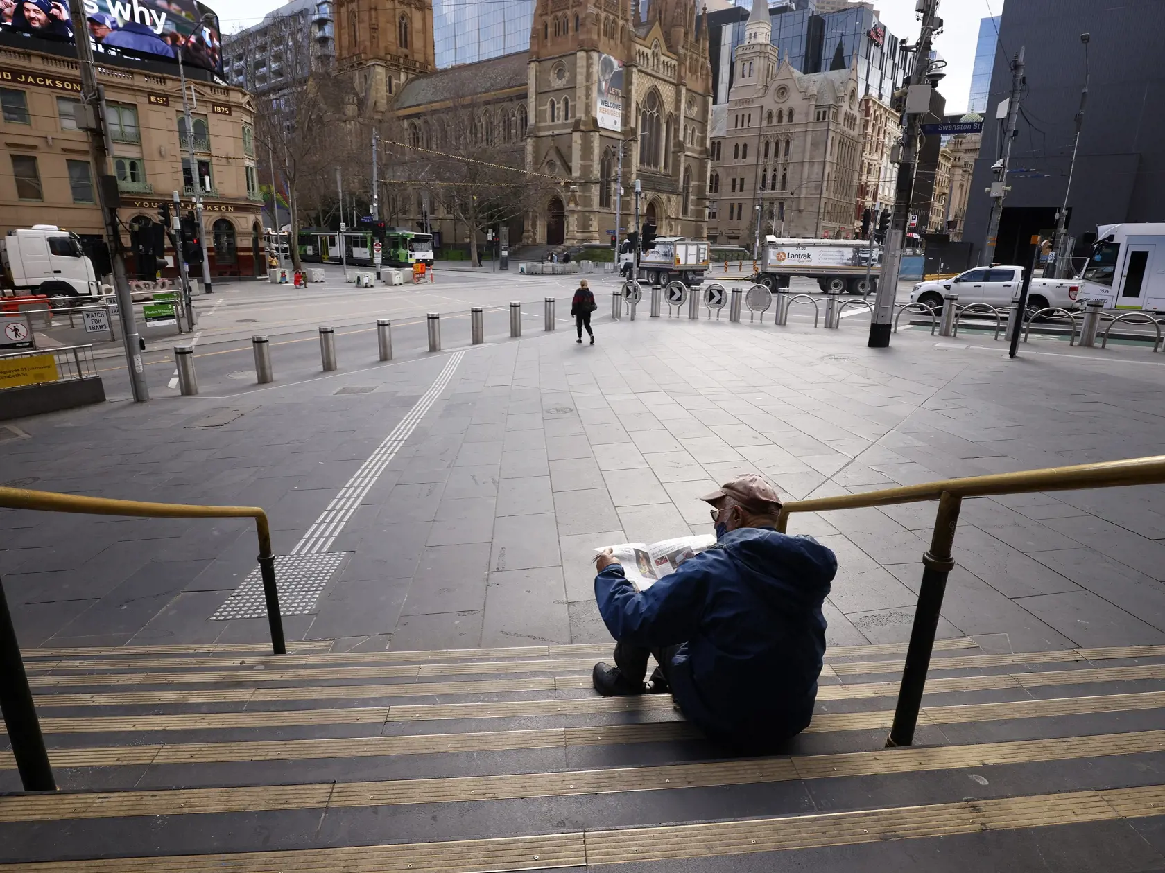 WA 12 Melbourne - Muž číta noviny na schodoch stanice v Melbourne v stredu 11. augusta 2021.  V druhom najväčšom austrálskom meste Melbourne predĺžili lockdown, aby úrady zamedzili šíreniu koronavírusu.  V Sydney, epicentre nákazy, trvá lockdown už sedem týždňov. Počet prípadov infekcie sa tam však aj napriek dlhotrvajúcim obmedzeniam stále udržiava na vysokej úrovni a v niekoľkých predmestiach sa od štvrtka úrady rozhodli zaviesť prísnejšie obmedzenia. Sedemdňový lockdown zaviedli aj v austráls