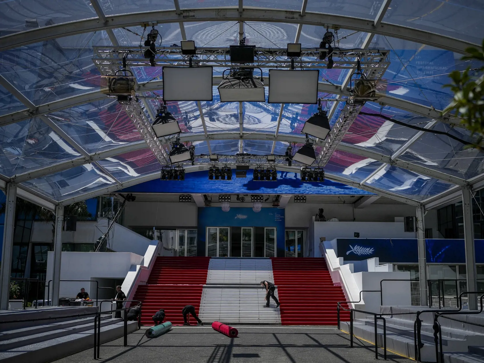 Zamestnanci festivalu inštalujú červený koberec počas príprav na 77. ročník medzinárodného filmového festivalu v Cannes v južnom Francúzsku v pondelok 13. mája 2024. Filmový festival v Cannes sa začne 14. mája a potrvá do 25. mája 2024.