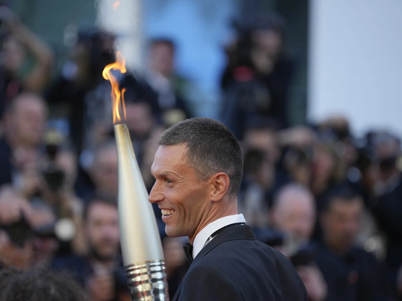 Francúzsky triatlonista Alexis Hanquinquant nesie olympijskú pochodeň na premiéru francúzsko-taliansko komediálneho filmu Marcello Mio na 77. medzinárodnom filmovom festivale v Cannes v južnom Francúzsku v utorok 21. mája 2024.