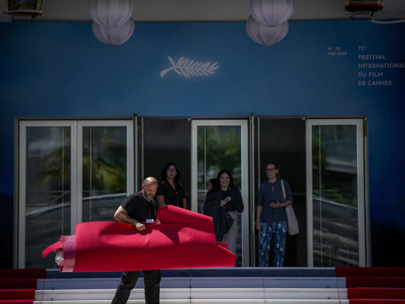 Zamestnanci festivalu inštalujú červený koberec počas príprav na 77. ročník medzinárodného filmového festivalu v Cannes v južnom Francúzsku v pondelok 13. mája 2024. Filmový festival v Cannes sa začne 14. mája a potrvá do 25. mája 2024.