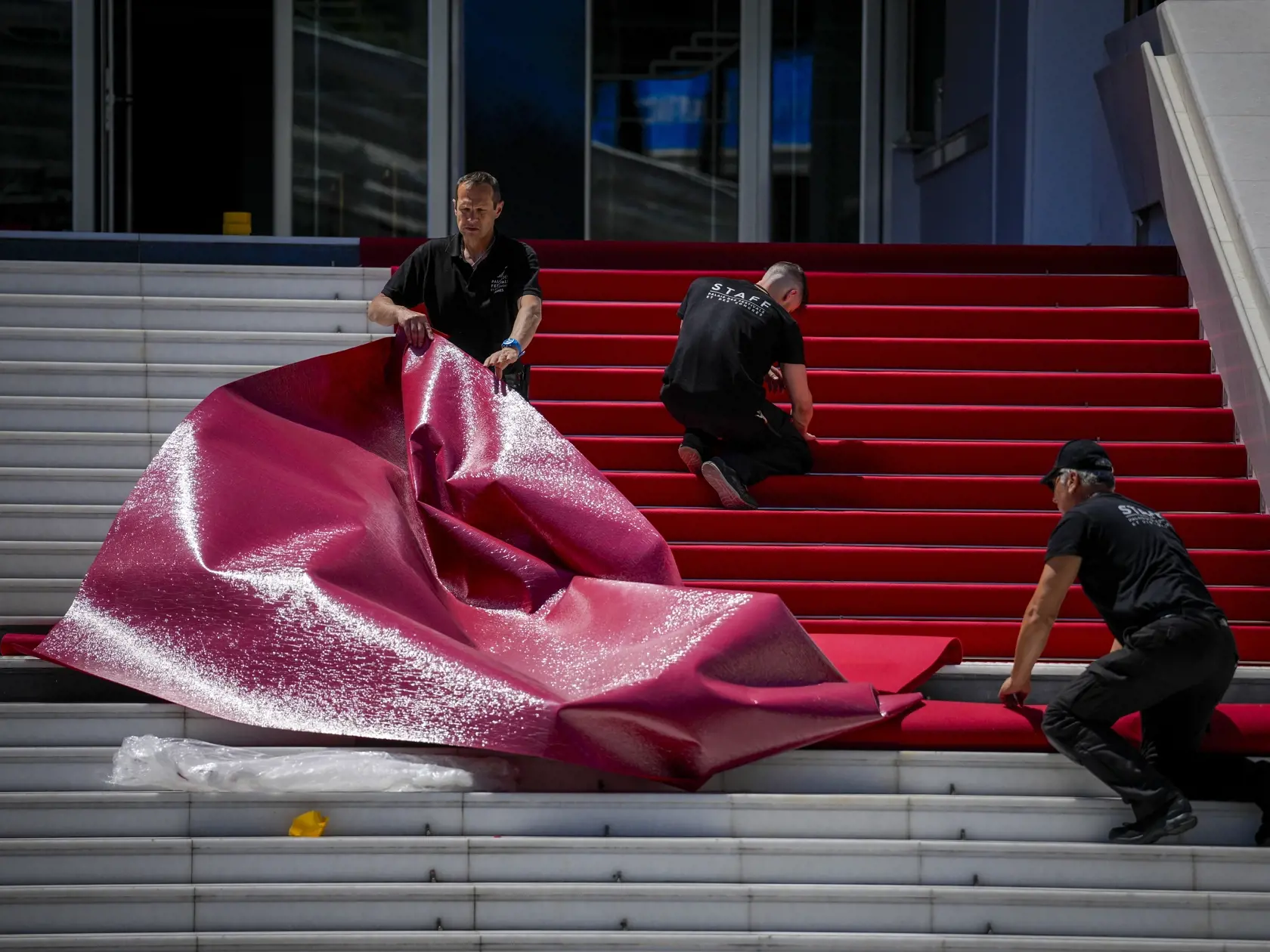 Zamestnanci festivalu inštalujú červený koberec počas príprav na 77. ročník medzinárodného filmového festivalu v Cannes v južnom Francúzsku v pondelok 13. mája 2024. Filmový festival v Cannes tsa začna 14. mája a potrvá do 25. mája 2024.