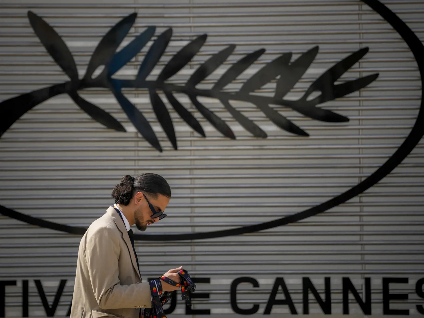Osoba prechádza okolo loga filmového festivalu v Cannes počas príprav nana 77. ročník medzinárodného filmového festivalu v Cannes v južnom Francúzsku v pondelok 13. mája 2024. Filmový festival v Cannes sa začne 14. mája a potrvá do 25. mája 2024.