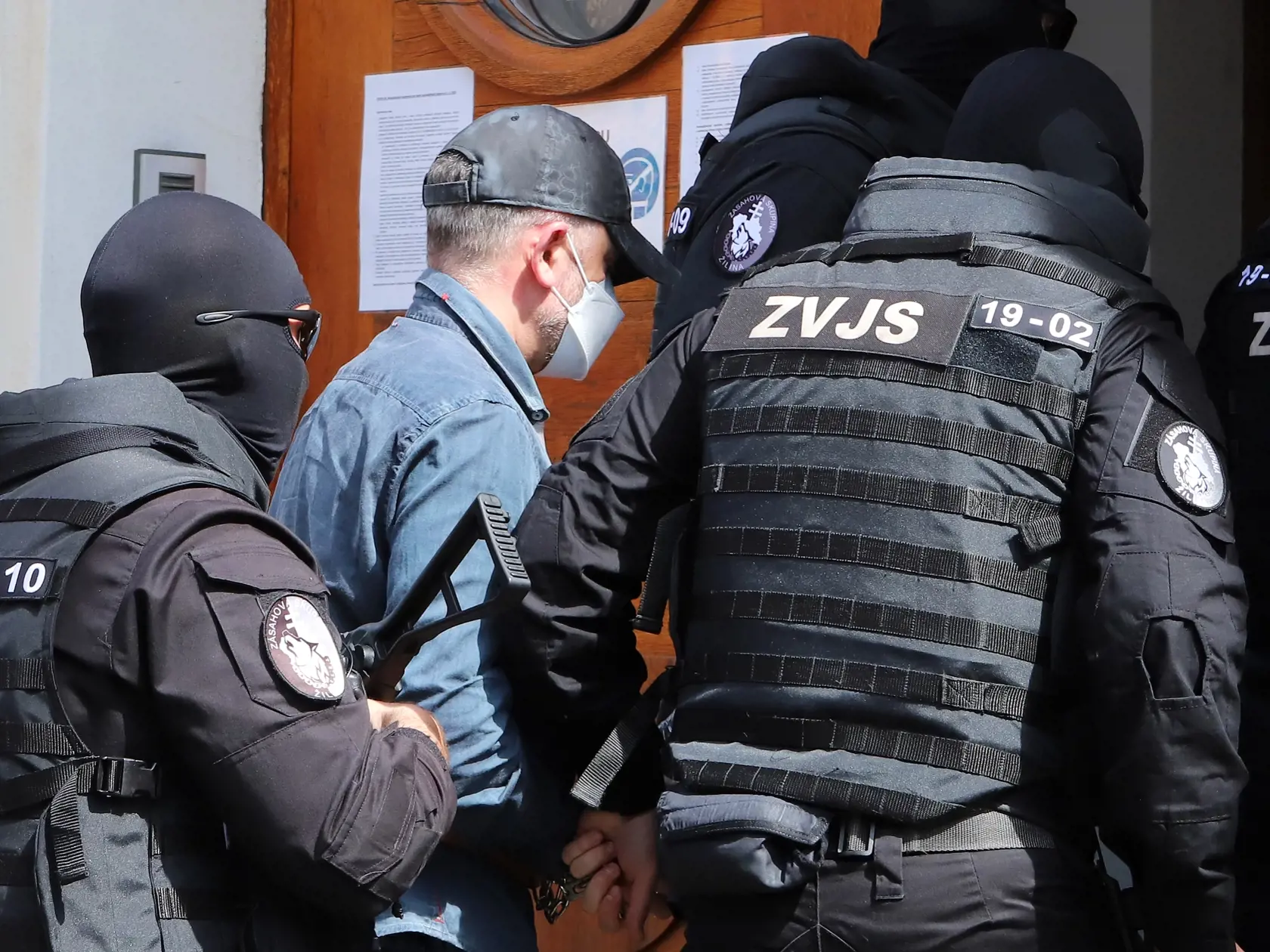 Sudca pre prípravné konanie Špecializovaného trestného súdu (ŠTS), pracovisko Banská Bystrica, rozhoduje o predĺžení väzby pre bývalého šéfa protikorupčnej jednotky Roberta K., v ktorej je od novembra 2020. NAKA ho vtedy zadržala v rámci policajnej akcie Očistec. Na snímke eskorta privádza obvineného bývalého šéfa protikorupčnej jednotky Roberta K. do budovy Špecializovaného trestného súdu (ŠTS) v Banskej Bystrici 10. mája 2021. FOTO TASR - Ján Krošlák