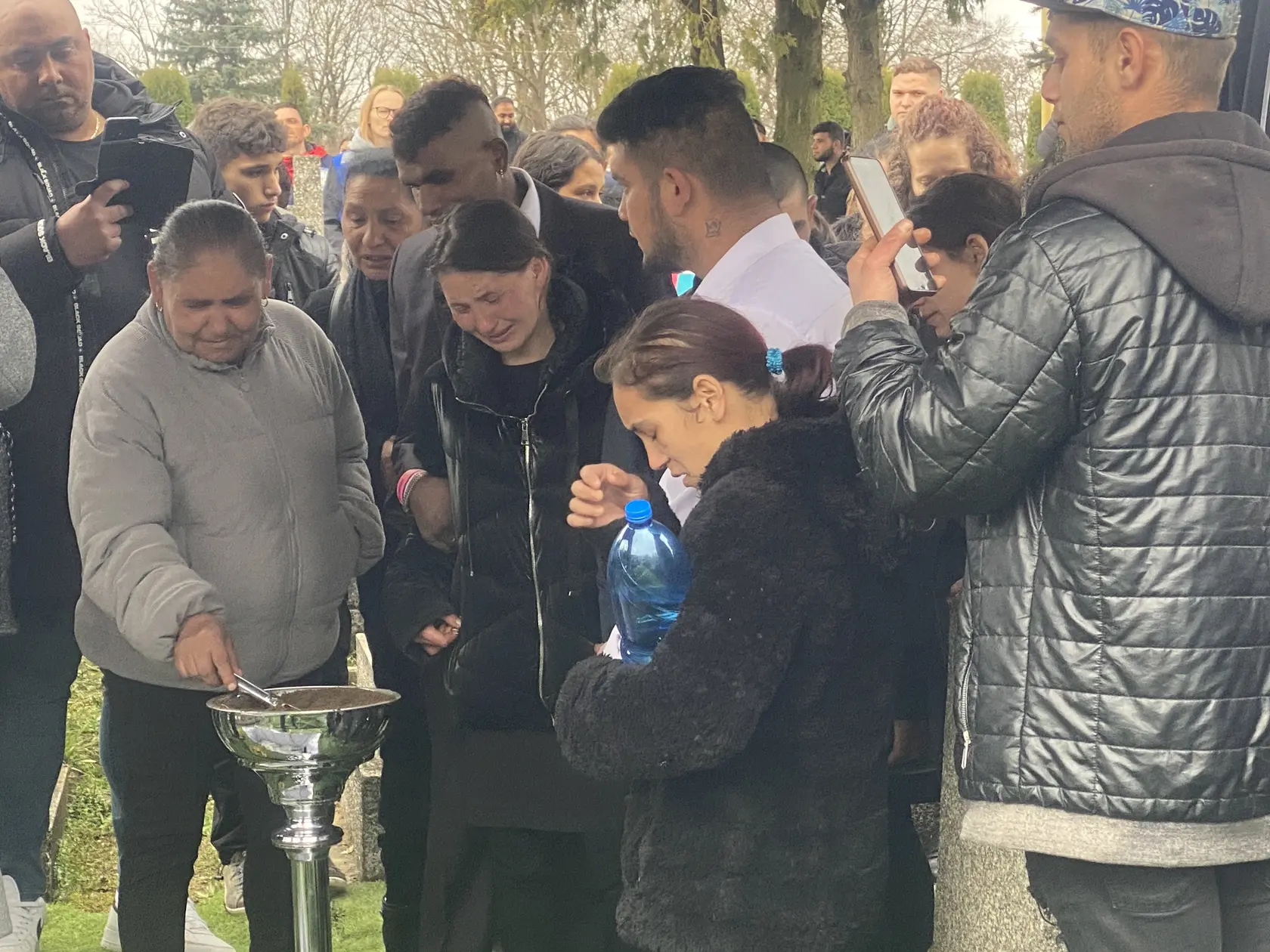 Zronená matka nad hrobom svojich detí a babičky. 