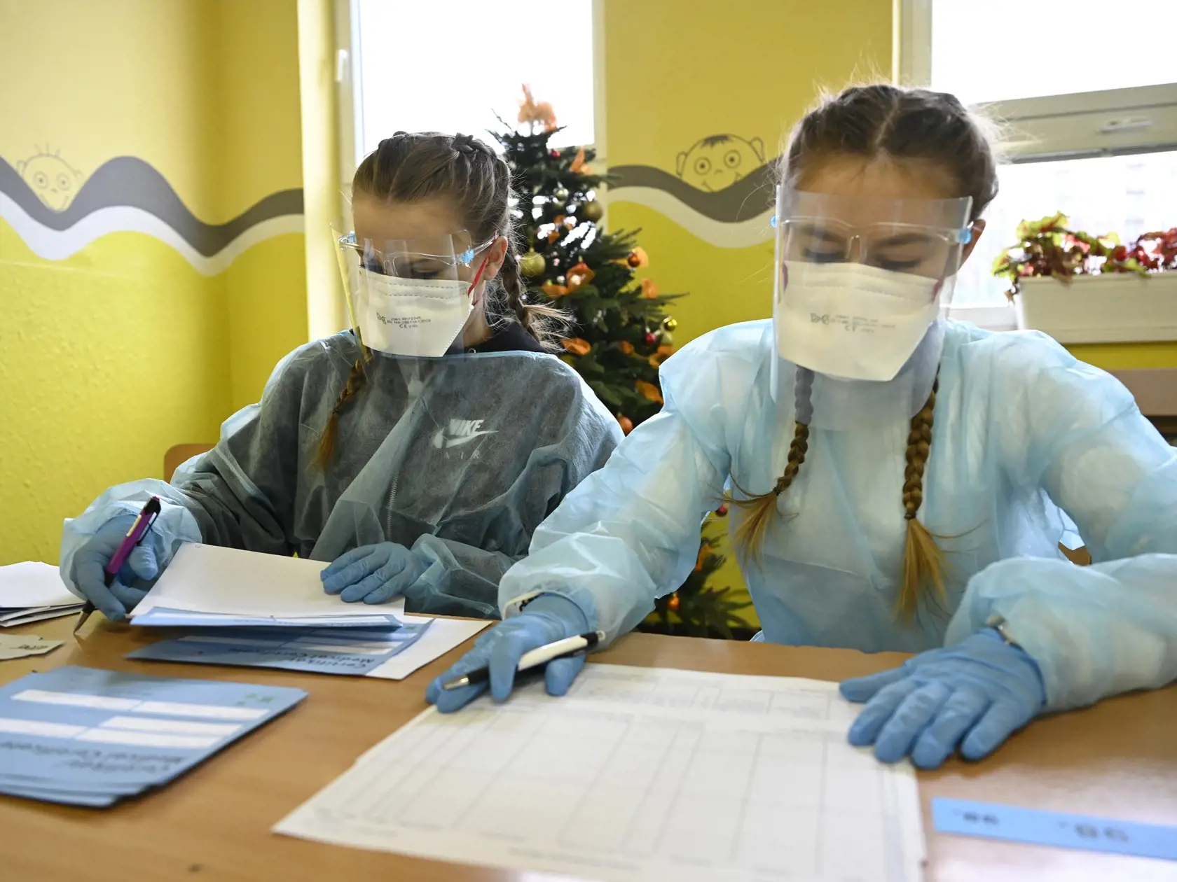 Dobrovoľníčky vypisujú certifikáty pre obyvateľov Trenčína, ktorí sa prišli otestovať na nový koronavírus do odberných miest v Základnej škole na Dlhých Honoch, 19. decembra 2020 v Trenčíne.