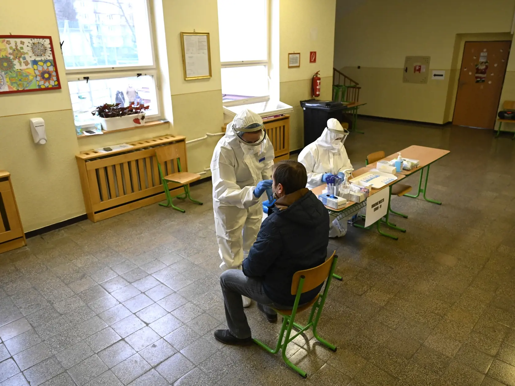 Zdravotníčka odoberá vzorku obyvateľovi Trenčína, ktorý prišiel na celoplošné testovanie obyvateľov mesta Trenčín na nový koronavírus na odberné miesto na Základnej škole na Dlhých Honoch, 19. decembra 2020 v Trenčíne.
