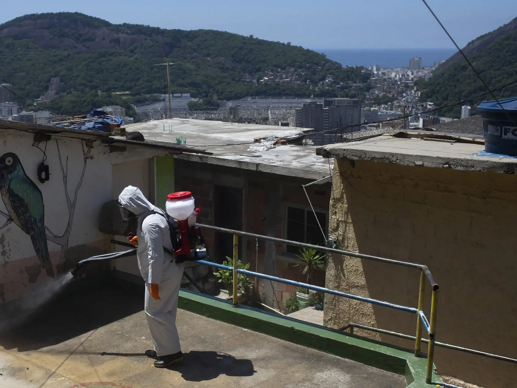 Dobrovoľník v ochrannom odeve dezinfikuje ulicu v slume Santa Marta na zabránenie šíreniu ochorenia COVID-19 spôsobeného novým koronavírusom v Rio de Janeiro 28. novembra 2020.
