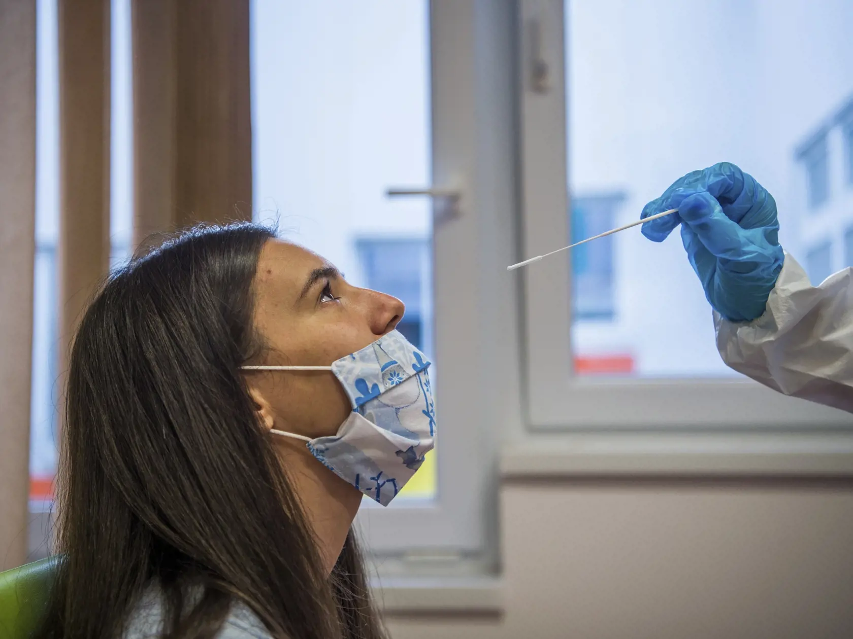 Študentka medicíny odoberá vzorku z nosa počas testovania zamestnankyne škôlky na ochorenie COVID-19 v Budapešti v pondelok 30. novembra 2020.