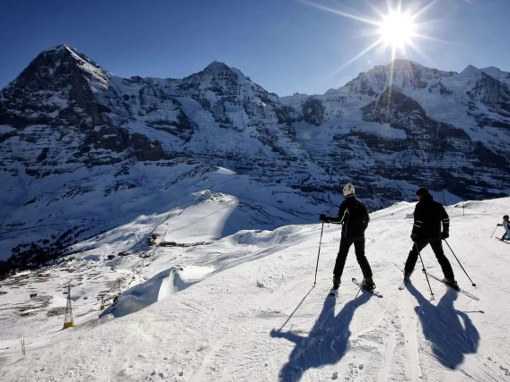 Lyžiari si vychutnávajú pohľad na Kleine Scheidegg (dole) a vrcholy Eiger, Mönch a Jungfrau na snímke z 13. januára 2009 blízko švajčiarskeho zimného strediska Lauberhorn.