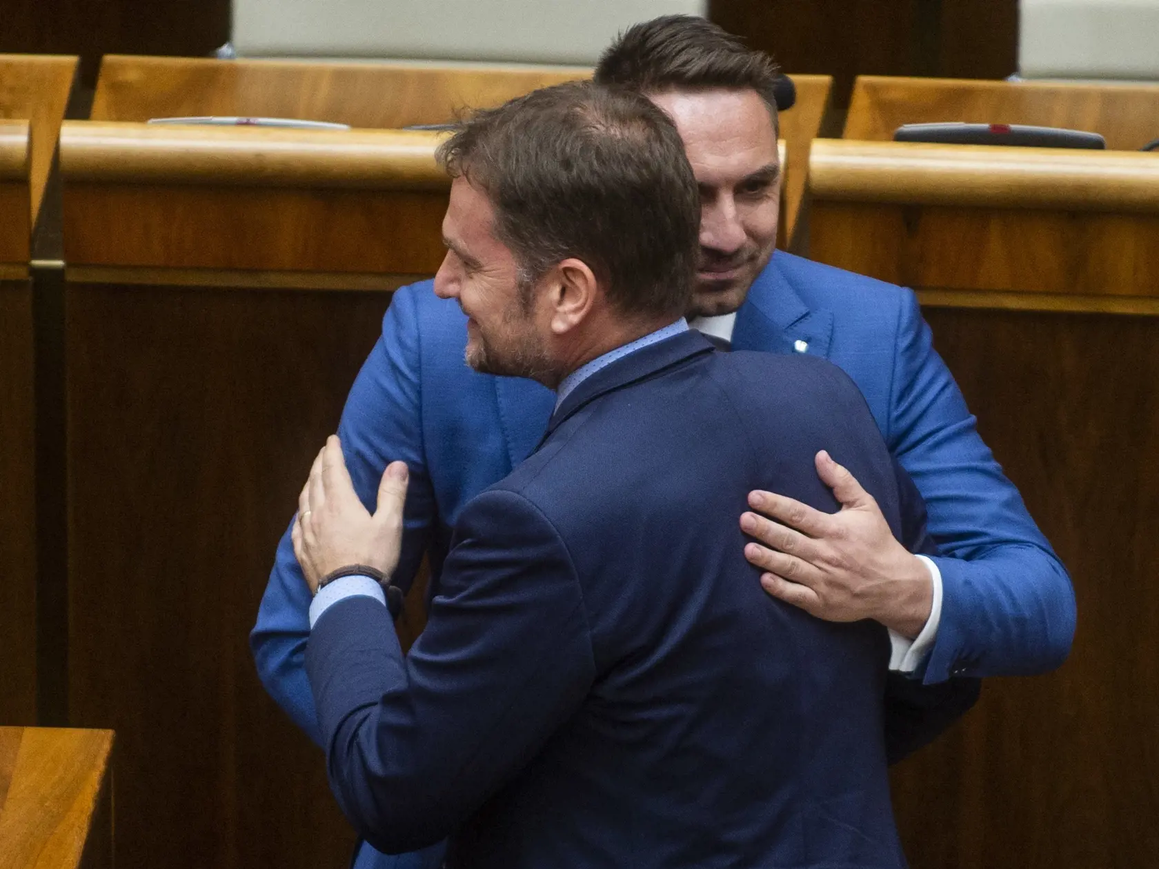 Na snímke chrbtom minister financií SR Igor Matovič a tvárou poslanec NR SR György Gyimesi (obaja OĽaNO) sa tešia po schválení protiinflačného balíka na pomoc rodinám z dielne ministra financií na 65. schôdzi parlamentu v Bratislave v utorok 24. mája 2022. Za hlasovalo 83 zo 131 prítomných poslancov. Na voľnočasové aktivity dostanú od januára budúceho roku deti od piatich do 18 rokov každý mesiac 60 eur. Zvýši sa aj suma daňového bonusu a vzrastie aj prídavok na dieťa - a to najskôr od júla toht