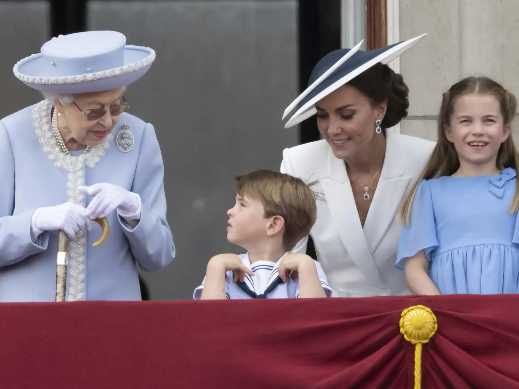 Vojvodkyňa Kate s deťmi princom Louisom a princeznou Charlotte bok po boku kráľovnej Alžbete II.