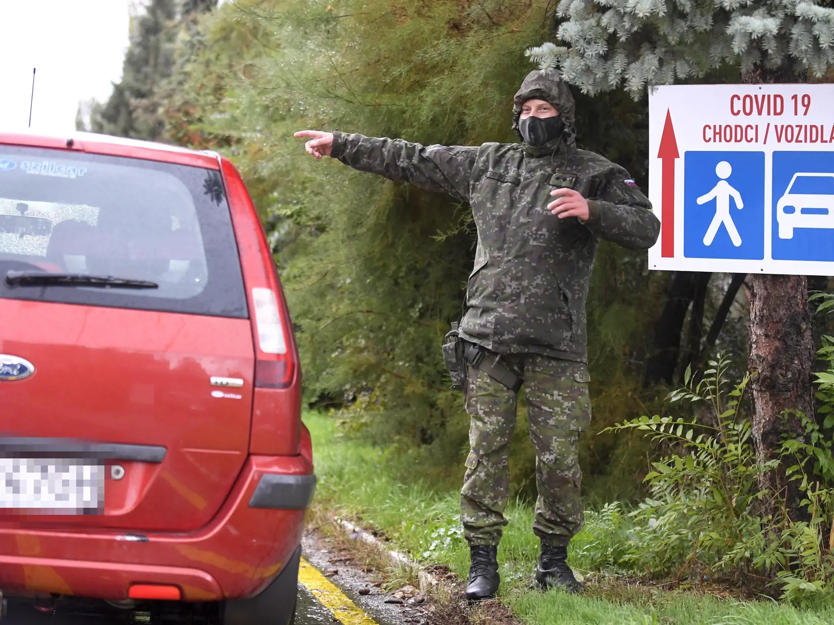 Pri veľkokapacitnom odberovom mieste na Ipeľskej ulici v Košiciach  vypomáhajú dvaja príslušníci ozbrojených síl SR, ktorí usmerňujú dopravu a dohliadajú na plynulosť testovania. Košice, 13. októbra 2020. FOTO TASR - František Iván