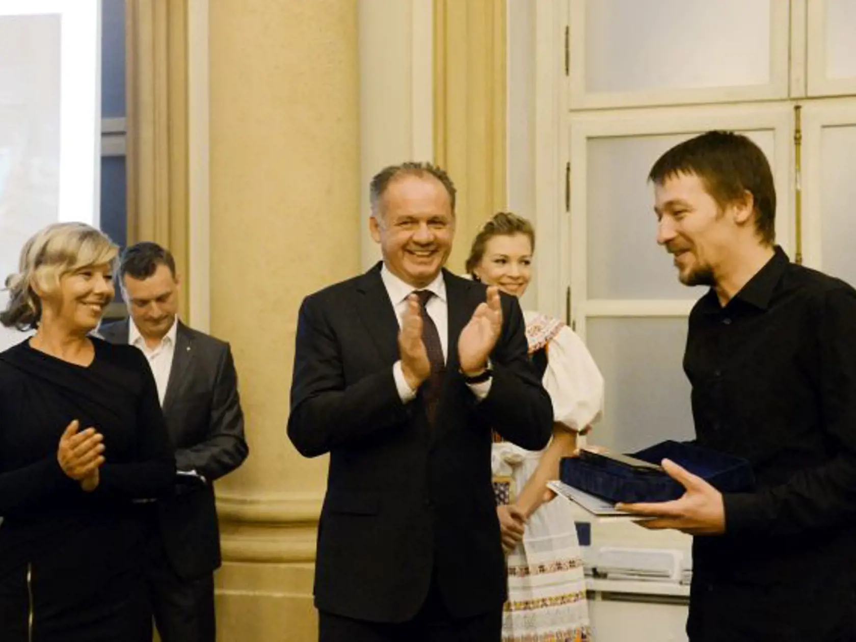 Na snímke prezident SR Andrej Kiska (uprostred) odovzdáva hlavnú cenu Grand Prix súťaže Slovak Press Foto fotoreportérovi Michalovi Burzovi (vpravo), riaditeľka súťaže Slovak Press Photo Jana Garvoldtová (prvá zľava) v Bratislave 22. októbra 2014. FOTO TASR - Štefan Puškáš. 