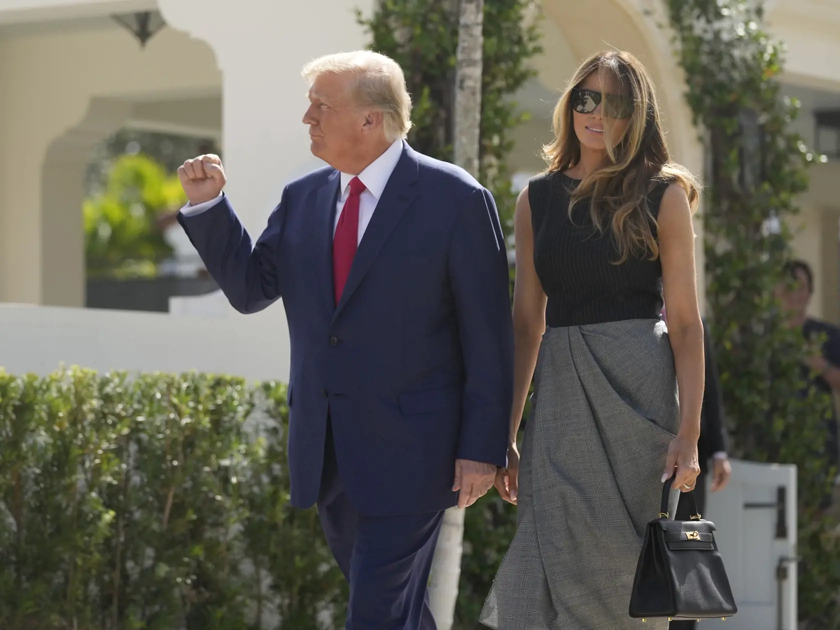 Bývalý americký prezident Donald Trump a jeho manželka Melania Trumpová vychádzajú z volebnej miestnosti v Palm Beach na Floride počas volieb do oboch komôr Kongresu v utorok 8. novembra 2022.