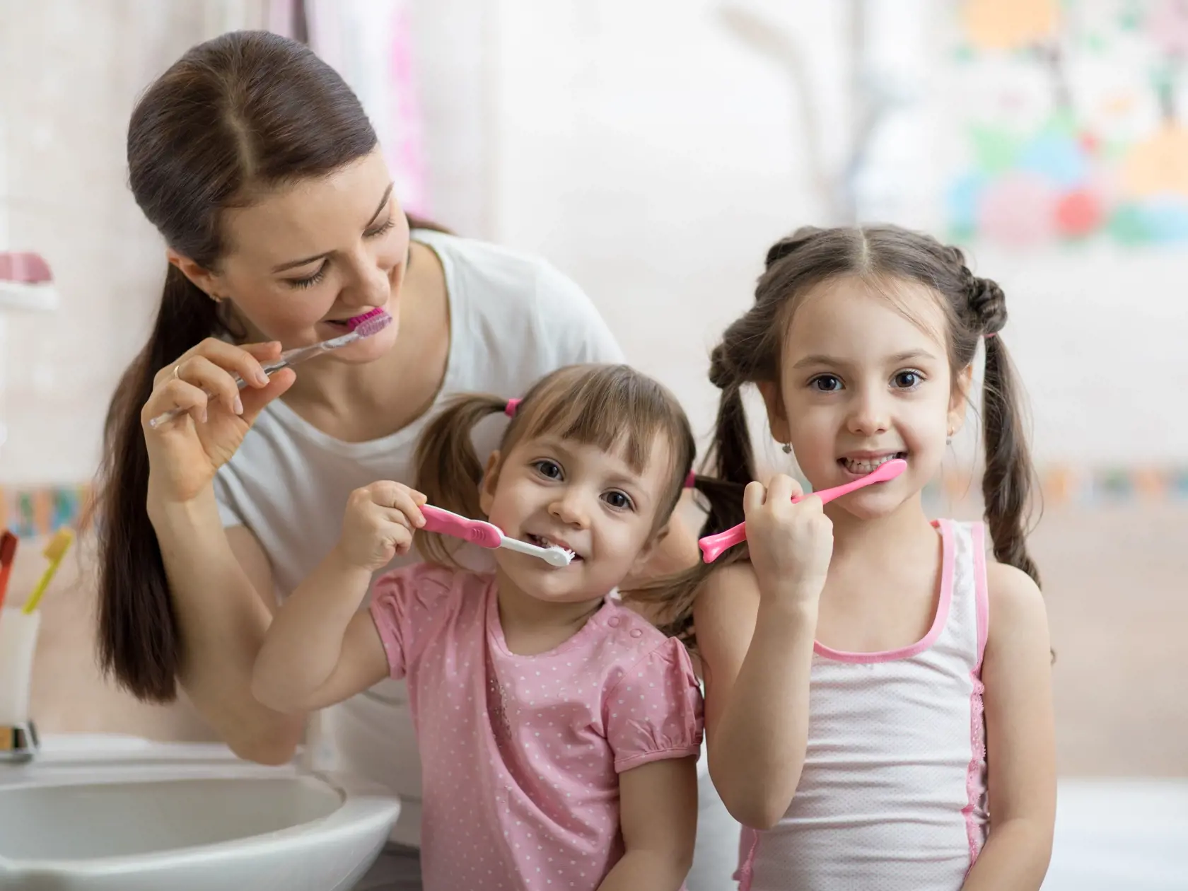 Family,Mom,And,Two,Daughters,Little,Girls,Brush,Their,Teeth