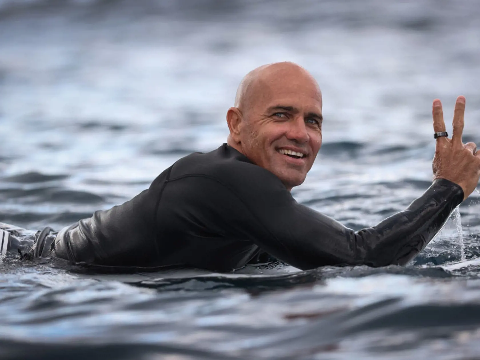 Tvár surfistu Kellyho Slatera je súmerná a len tak žiari.