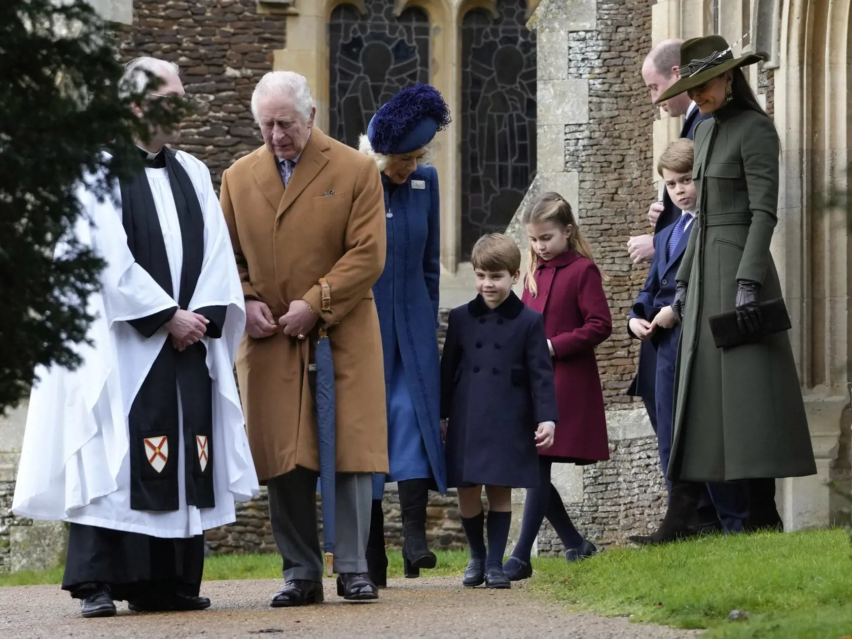 Na snímke britský kráľ Karol III., britská kráľovná manželka Kamila, princ Louis, princezná Charlotte, princ George, princ William a jeho manželka Kate odchádzajú z tradičnej vianočnej bohoslužby v obci Sandringham v anglickom grófstve Norfolk 25. decembra 2022.