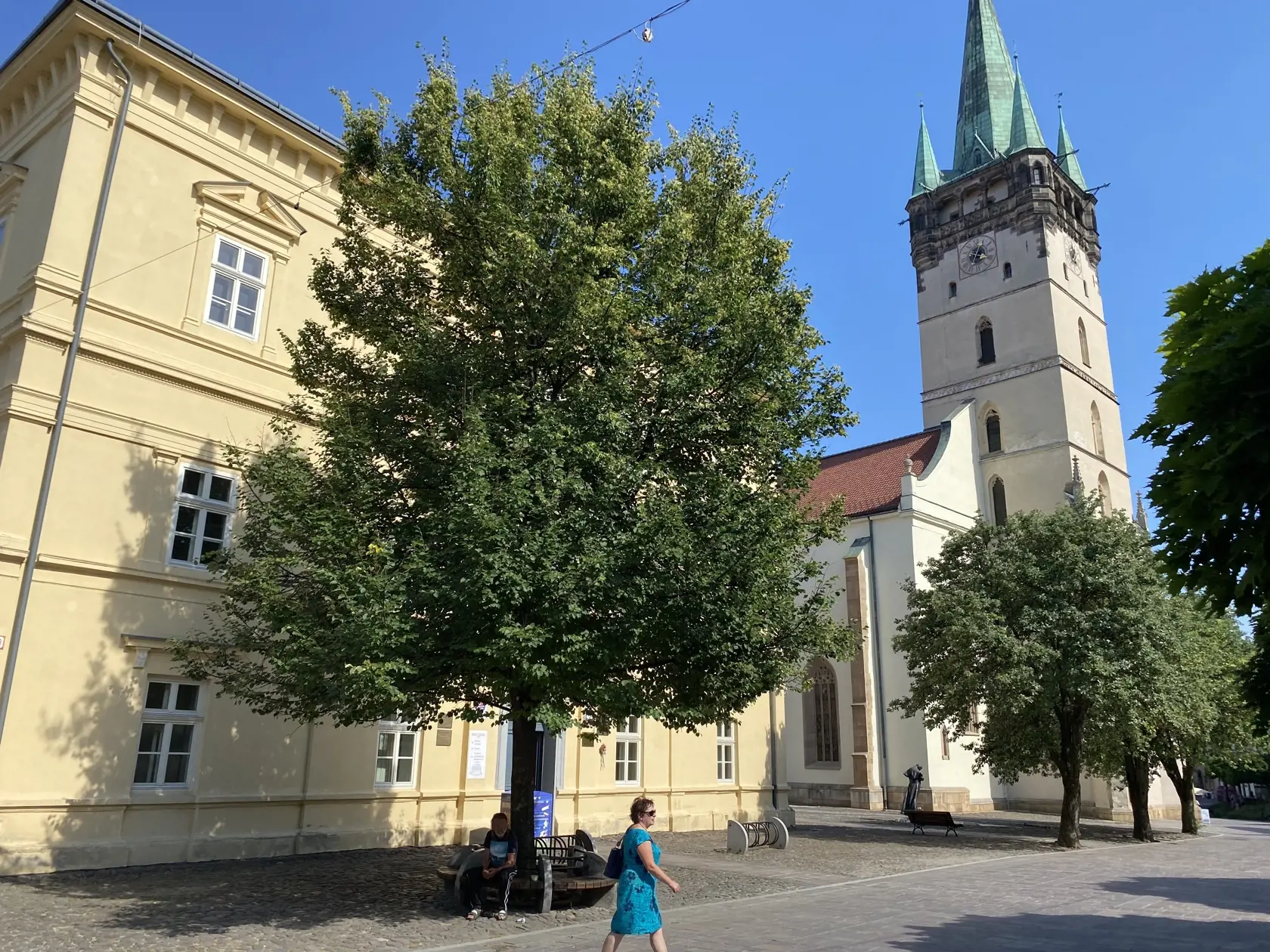 Centrum Prešova. Kamennú dlažbu medzi budovou knižnice patriacej Prešovskému samosprávnemu kraju a Konkatedrálou, pod tieňmi stromov , si vybral konzul na parkovanie svojho služobného auta.
