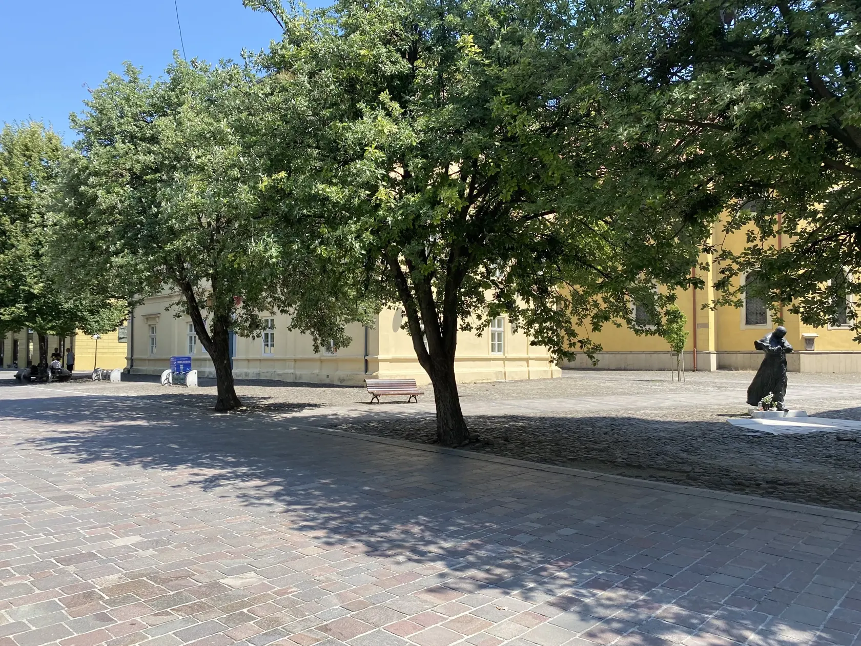 Centrum Prešova. Kamennú dlažbu medzi budovou knižnice patriacej Prešovskému samosprávnemu kraju a Konkatedrálou, pod tieňmi stromov , si vybral konzul na parkovanie svojho služobného auta.
