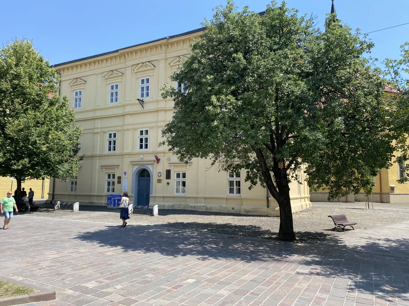 Centrum Prešova. Kamennú dlažbu medzi budovou knižnice patriacej Prešovskému samosprávnemu kraju a Konkatedrálou, pod tieňmi stromov , si vybral konzul na parkovanie svojho služobného auta.