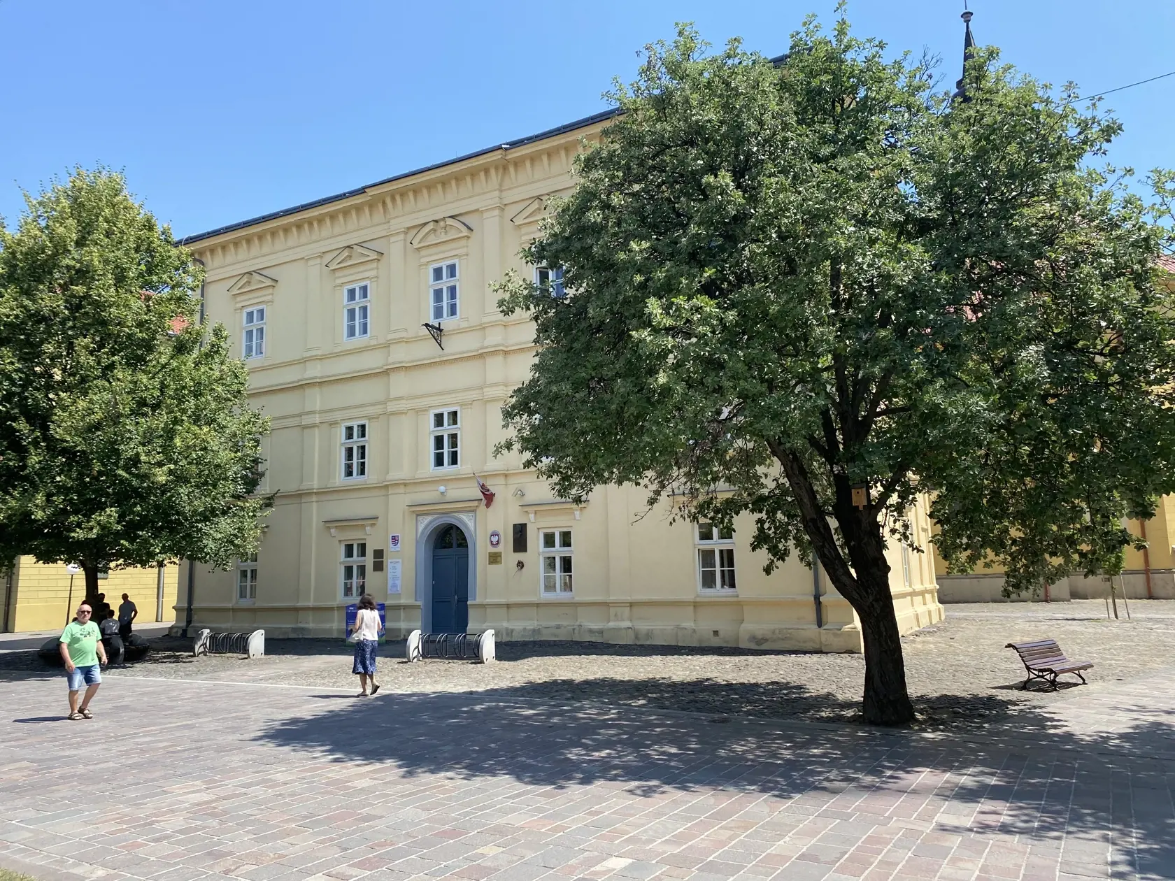 Centrum Prešova. Kamennú dlažbu medzi budovou knižnice patriacej Prešovskému samosprávnemu kraju a Konkatedrálou, pod tieňmi stromov , si vybral konzul na parkovanie svojho služobného auta.