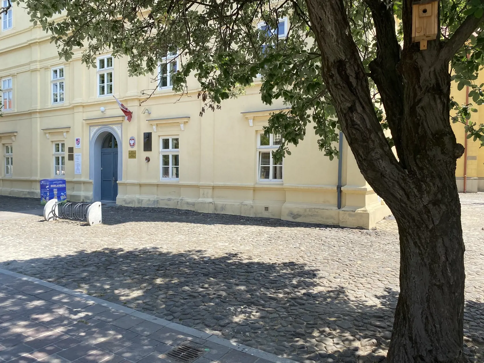 Centrum Prešova. Kamennú dlažbu medzi budovou knižnice patriacej Prešovskému samosprávnemu kraju a Konkatedrálou, pod tieňmi stromov , si vybral konzul na parkovanie svojho služobného auta.