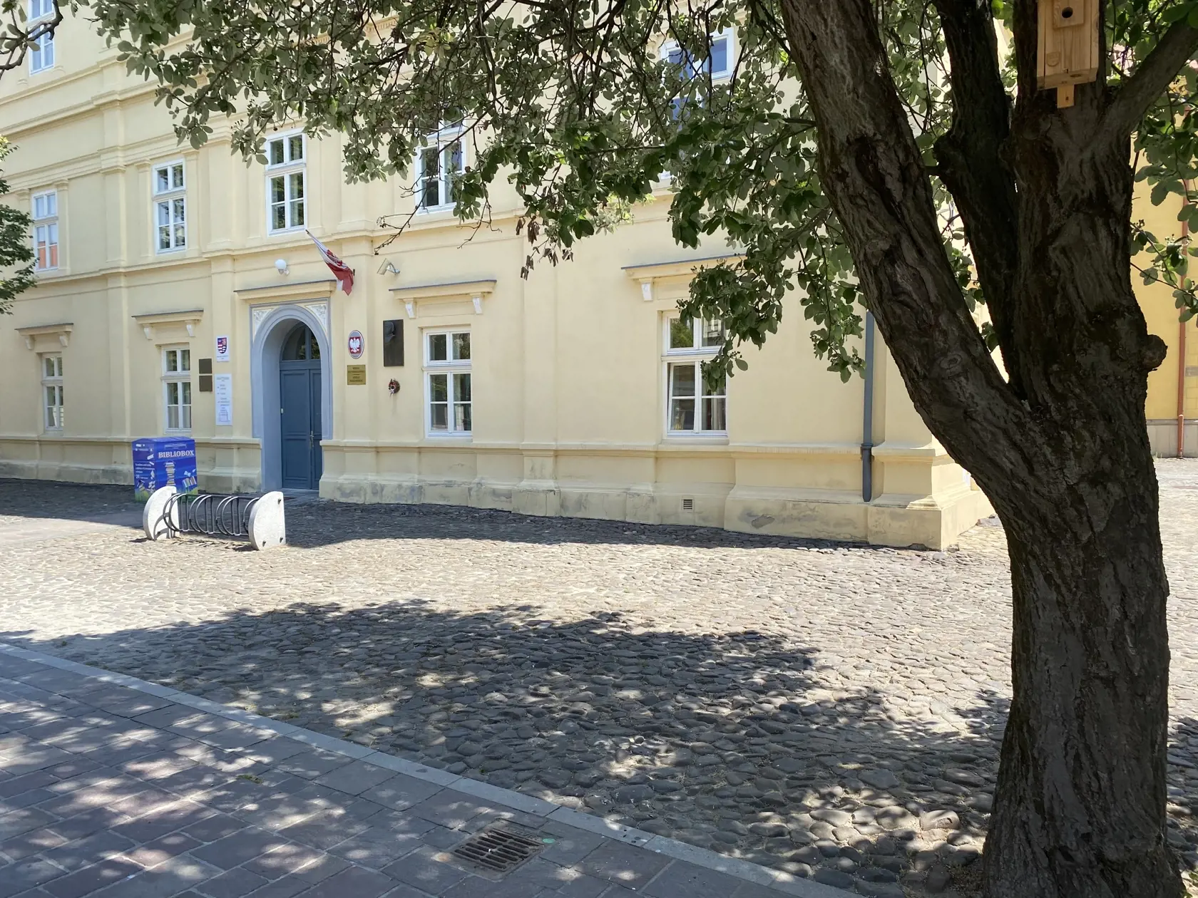 Centrum Prešova. Kamennú dlažbu medzi budovou knižnice patriacej Prešovskému samosprávnemu kraju a Konkatedrálou, pod tieňmi stromov , si vybral konzul na parkovanie svojho služobného auta.
