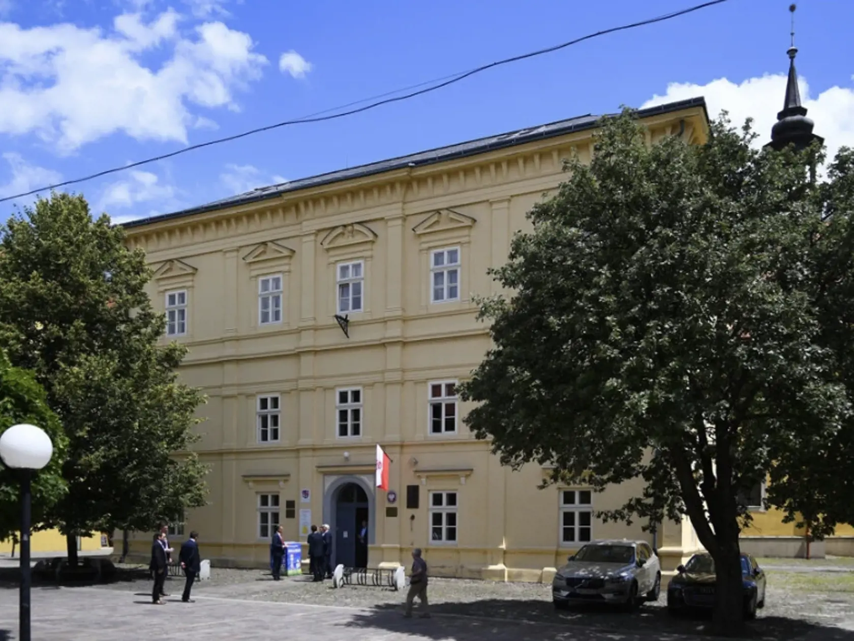 Centrum Prešova. Kamennú dlažbu medzi budovou knižnice patriacej Prešovskému samosprávnemu kraju a Konkatedrálou, pod tieňmi stromov , si vybral konzul na parkovanie svojho služobného auta.