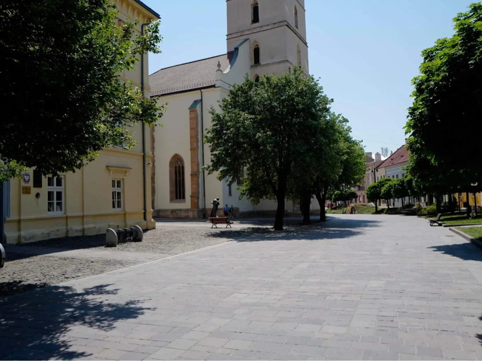 Centrum Prešova. Kamennú dlažbu medzi budovou knižnice patriacej Prešovskému samosprávnemu kraju a Konkatedrálou, pod tieňmi stromov , si vybral konzul na parkovanie svojho služobného auta.