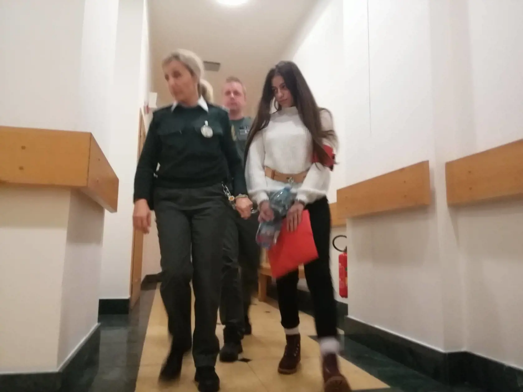 Mladú Juditu odvádzajú z pojednávacej miestnosti.