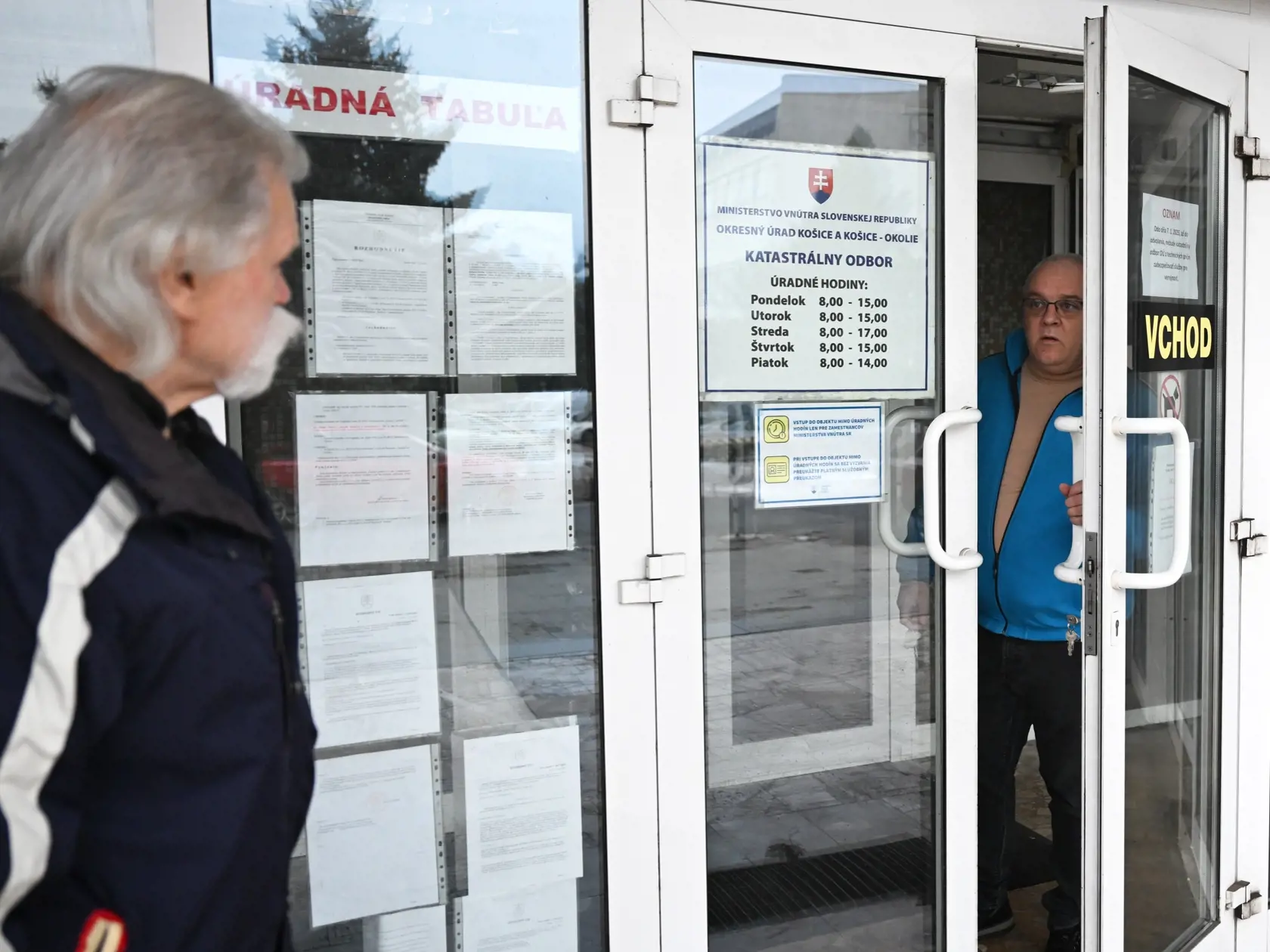 Vrátnik (vpravo) informuje občana o zatvorení Katastrálneho odboru Okresného úradu (OÚ) kvôli kybernetickému útoku v Košiciach 9. januára 2025.