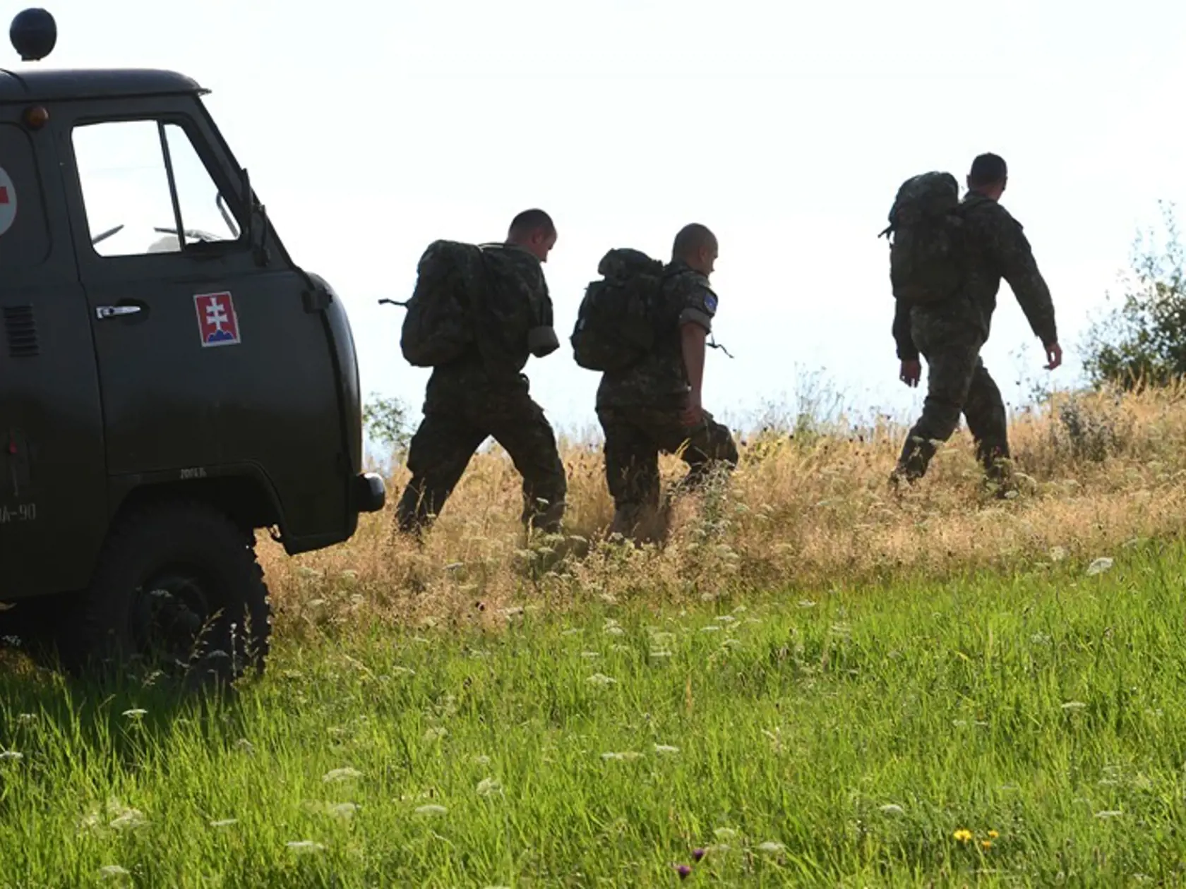 Príslušníci armády kráčajú k miestu pádu vojenského vrtuľníka.