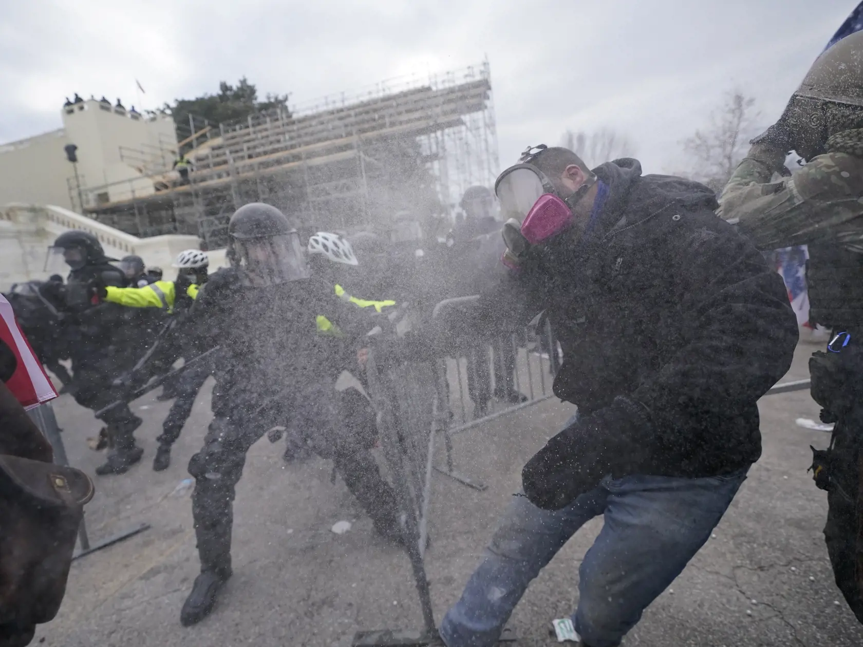 KK9 Washington - Na snímke stúpenci amerického prezidenta Donalda Trumpa sa snažia dostať cez bariéry pred budovou Kapitolu vo Washingtone 6. januára 2021. Počas potýčok medzi protestujúcimi a policajtmi v sídle amerického Kongresu bola postrelená jedna osoba, ktorú previezli do nemocnice, informovala agentúra AP. Demonštranti podporujúci prezidenta Donalda Trumpa predtým prenikli do budovy Kapitolu a dostali sa aj do zasadacej sály Senátu, ukazujú zábery televízií C-Span a NBC. FOTO TASR/AP 

T