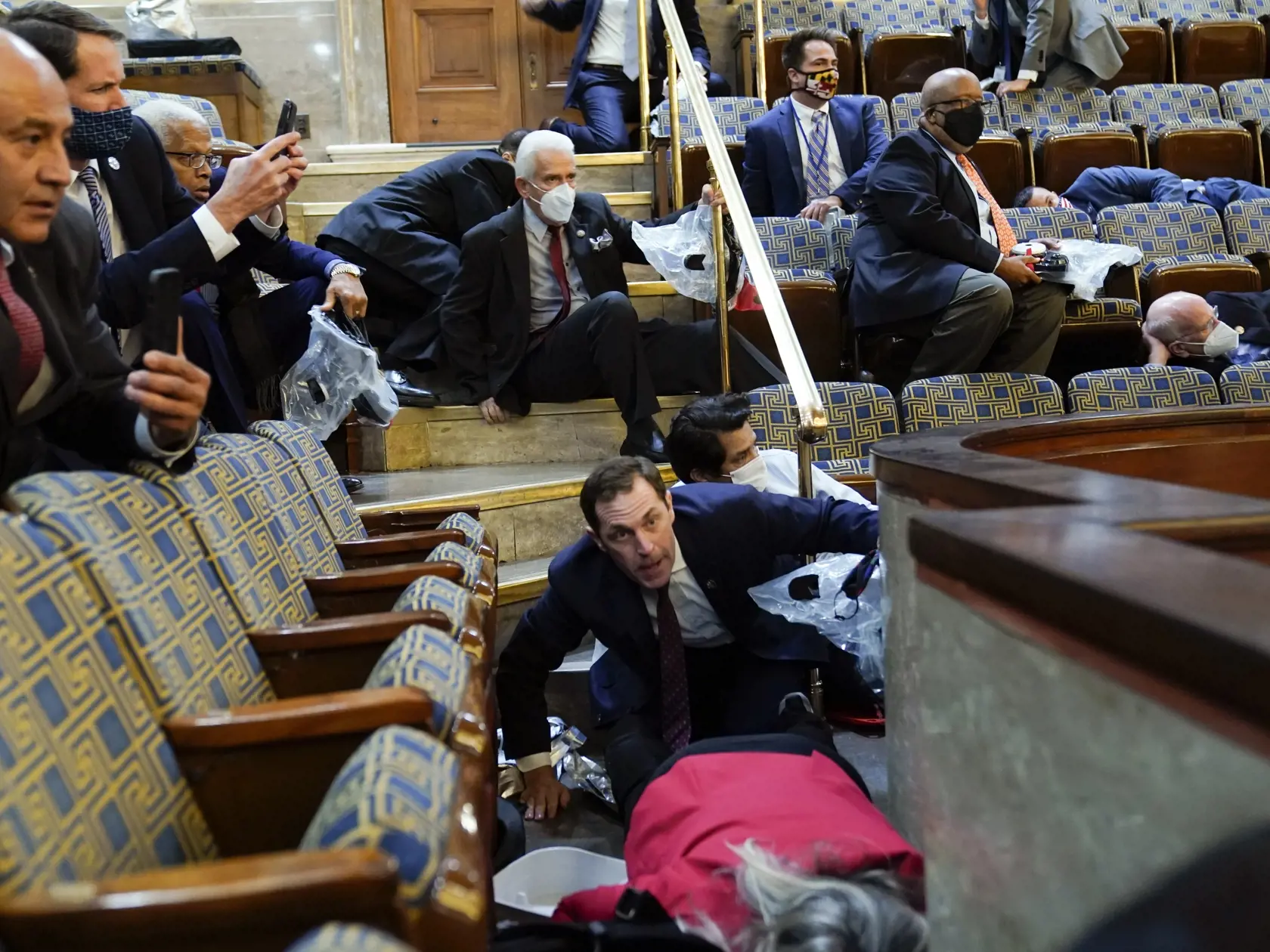 KK2 Washington - Na snímke ľudia sa ukrývajú po tom, čo protestujúci vtrhli do sídla amerického Kongresu vo Washingtone 6. januára 2021. Počas potýčok medzi protestujúcimi a policajtmi v sídle amerického Kongresu bola postrelená jedna osoba, ktorú previezli do nemocnice, informovala agentúra AP. Demonštranti podporujúci prezidenta Donalda Trumpa predtým prenikli do budovy Kapitolu a dostali sa aj do zasadacej sály Senátu, ukazujú zábery televízií C-Span a NBC. FOTO TASR/AP 

People shelter in th