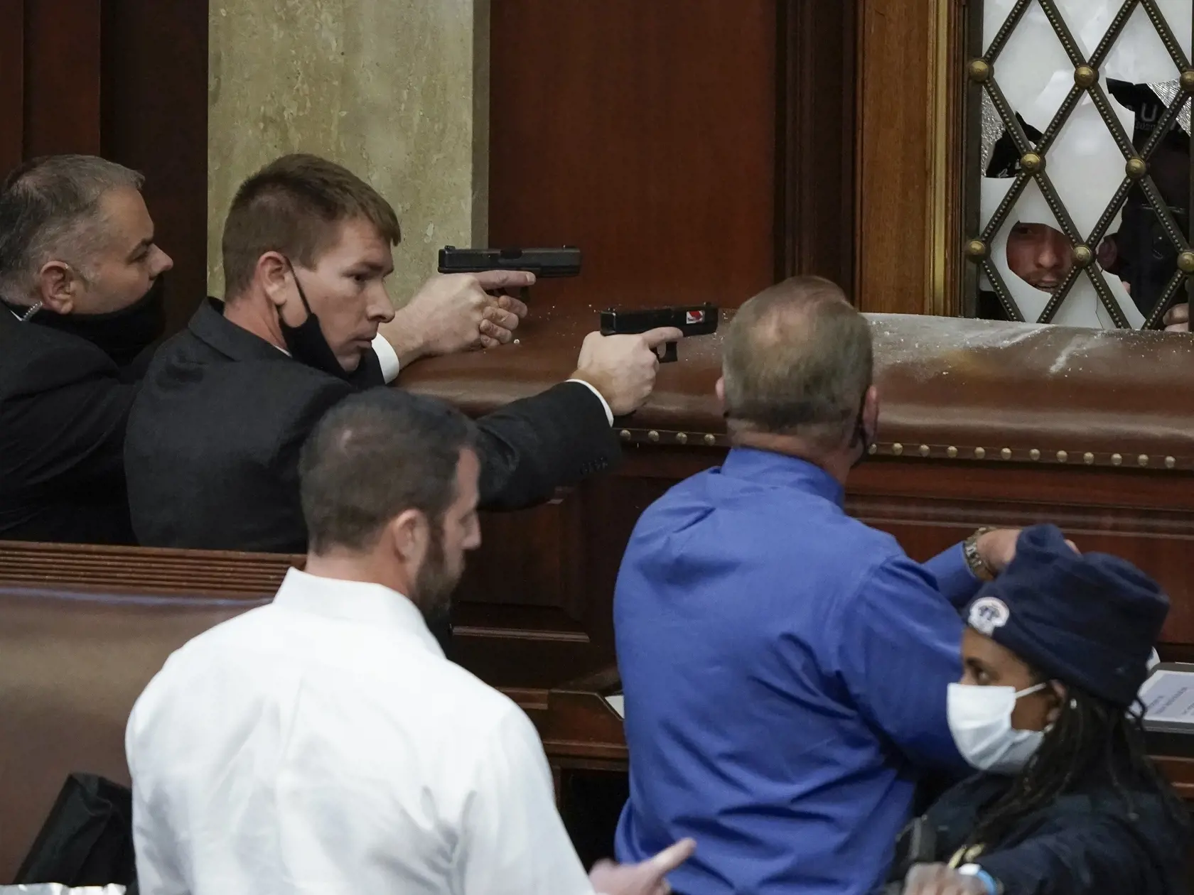 Na snímke policajti mieria zbraňami na protestujúcich, ktorí vtrhli do sídla amerického Kongresu vo Washingtone, 6. januára 2021. Počas potýčok medzi protestujúcimi a policajtmi v sídle amerického Kongresu bola postrelená jedna osoba, ktorú previezli do nemocnice, informovala agentúra AP. Demonštranti podporujúci prezidenta Donalda Trumpa predtým prenikli do budovy Kapitolu a dostali sa aj do zasadacej sály Senátu, ukazujú zábery televízií C-Span a NBC. FOTO TASR/AP 

U.S. Capitol Police with gu