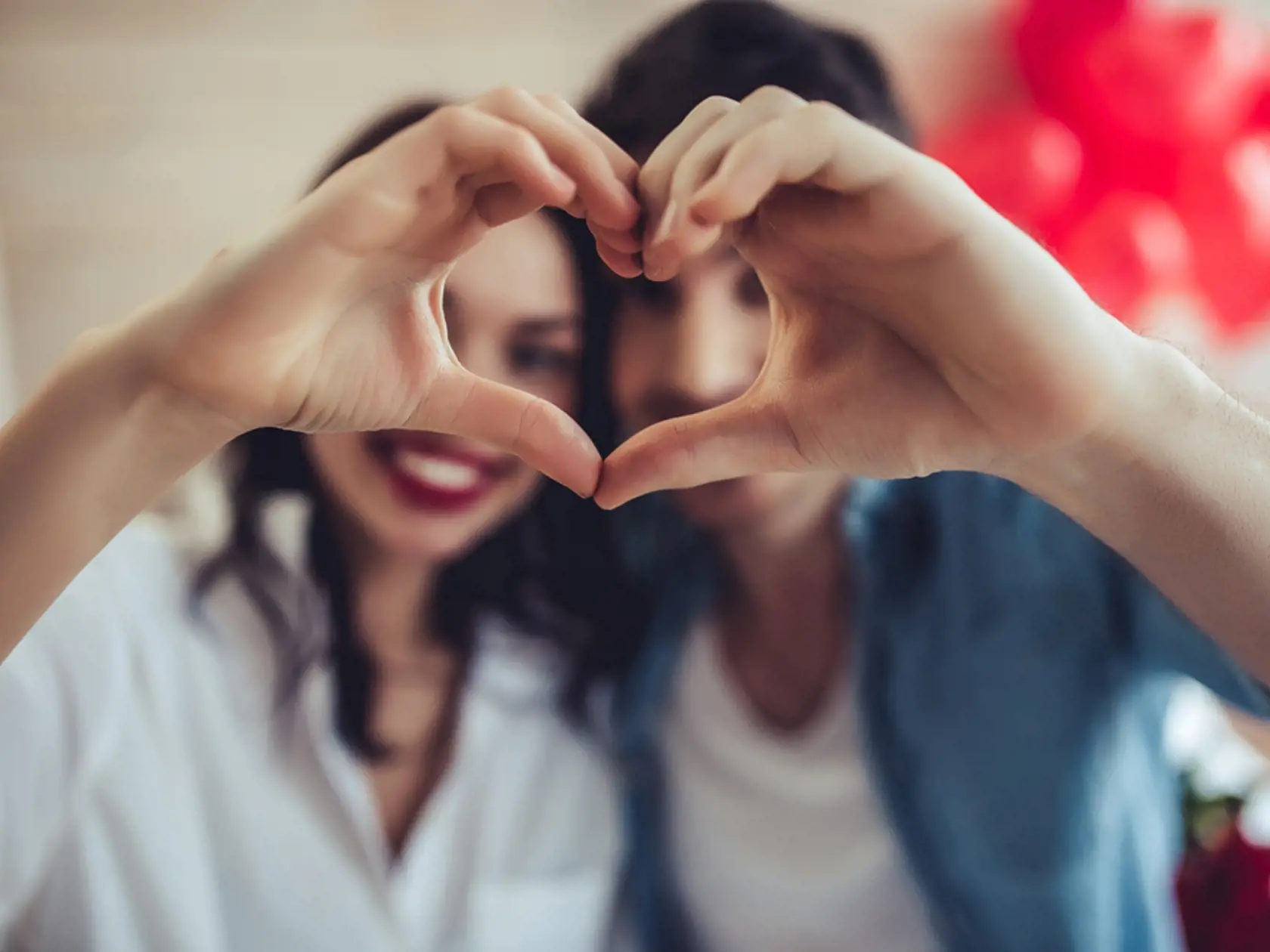 Beautiful,Young,Couple,At,Home,Is,Making,Heart,Sign,With