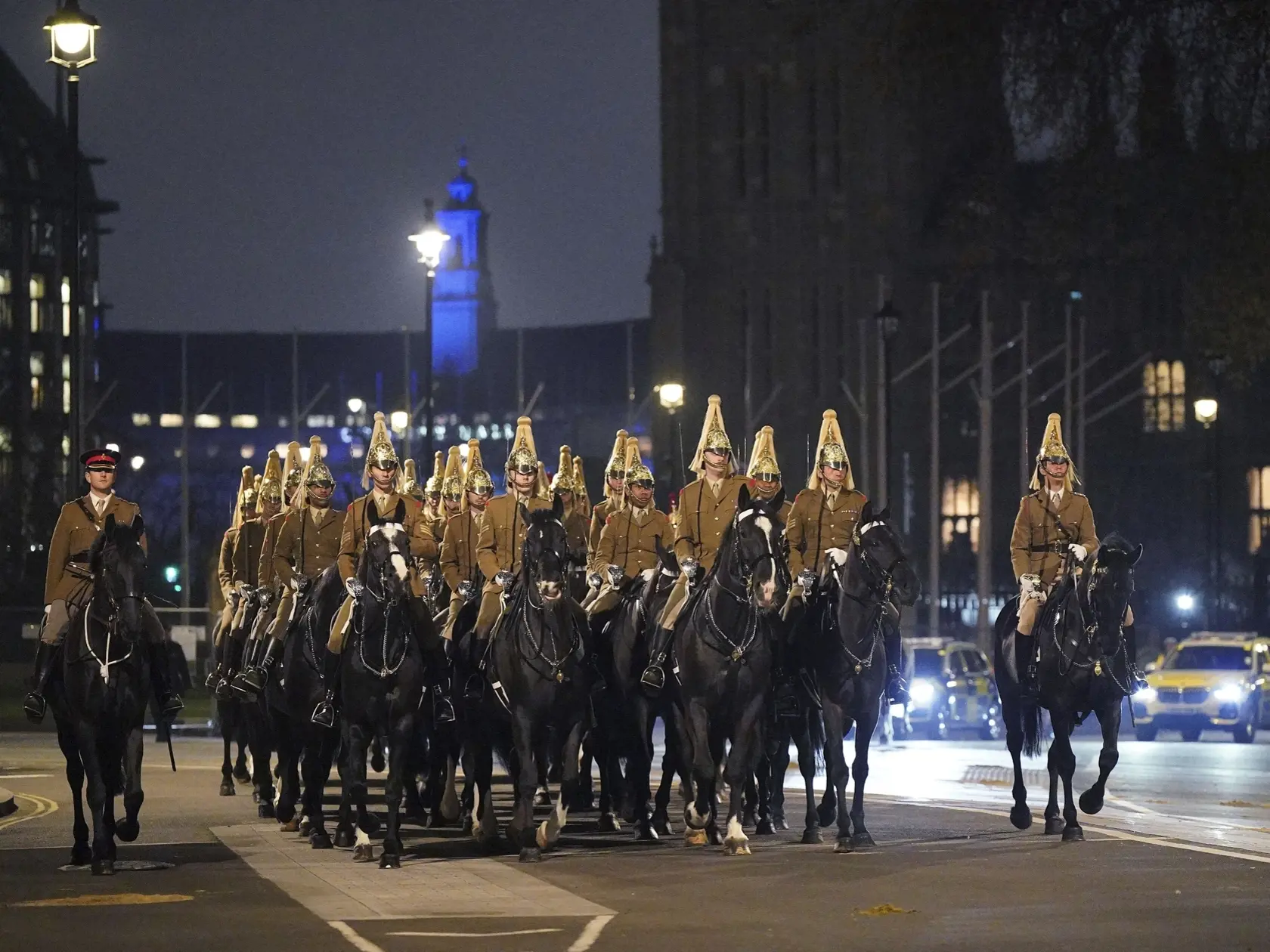 Príslušníci britskej armády, ktorí  nacvičujú vojenský korunovačný sprievod, prechádzajú okolo Westminsterského opátstva v  Londýne v skorých ranných hodinách v utorok 18. apríla 2023. Korunovácia ich veličenstiev kráľa Karola III. a kráľovnej Kamily sa uskutoční 6. mája.