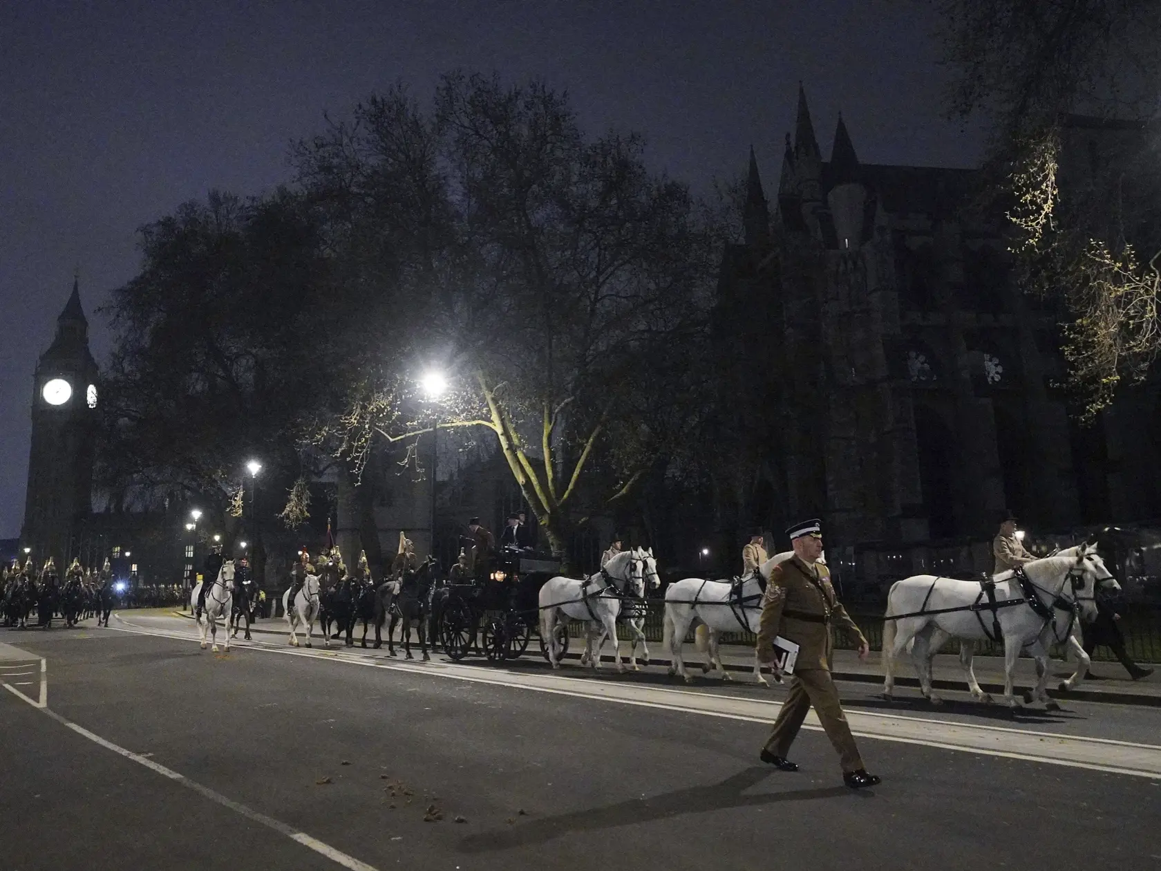Príslušníci britskej armády prechádzajú počas nočného nácviku korunovácie pred Westminsterským opátstvom v centre Londýna v utorok 18. apríla 2023. Korunovácia ich veličenstiev kráľa Karola III. a kráľovnej Kamily sa uskutoční 6. mája.