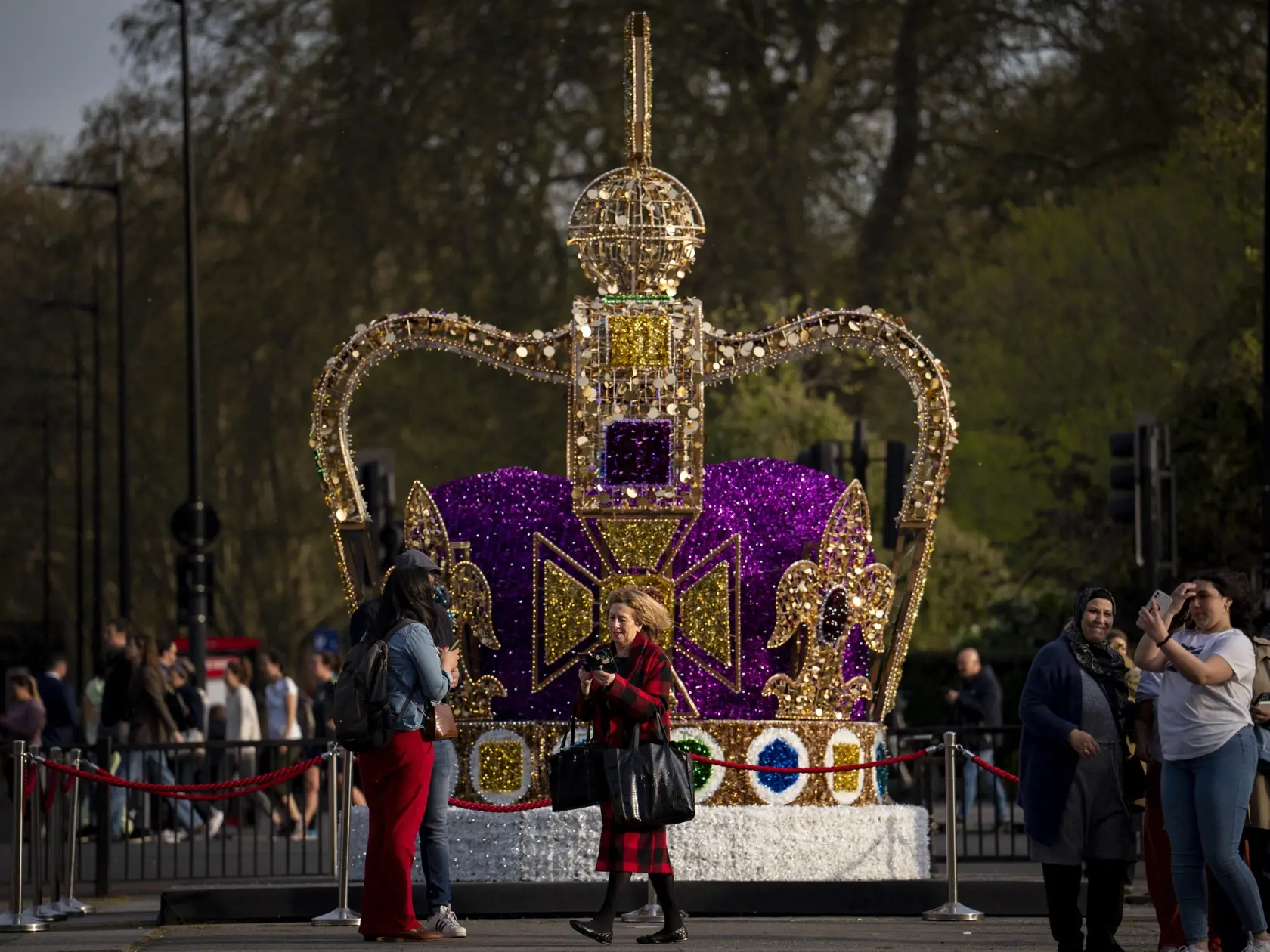 Ľudia kráčajú okolo umeleckej inštalácie, ktorá zobrazuje korunu svätého Eduarda v centre Londýna v utorok 3. mája 2023. Korunovácia britského kráľa Karola III. a jeho manželky Kamily sa bude konať vo Westminsterskom opátstve v sobotu 6. mája. Historická koruna svätého Eduarda je v Anglicku už viac než 350 rokov ústredným prvkom korunovácie panovníkov. Koruna je obvykle súčasťou korunovačných klenotov vystavených v londýnskom Toweri.