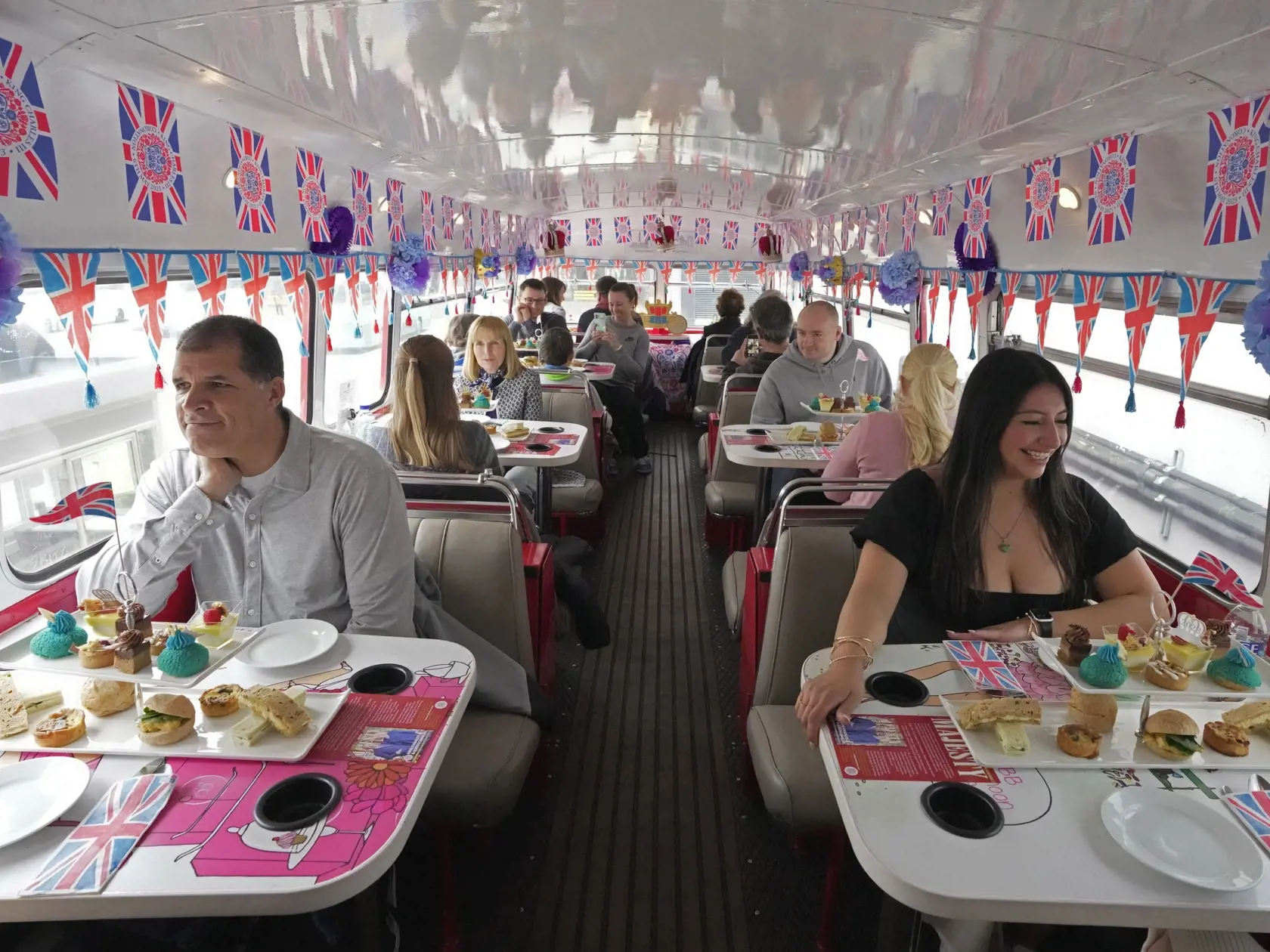 KK33 Londýn - Na snímke turisti sedia v korunovačnom turistickom autobuse počas prehliadky v Londýne 24. apríla 2023. Korunovácia Karola III. vo Westminsterskom opátstve sa bude konať 6. mája a zúčastnia sa na nej predstavitelia mnohých krajín sveta. FOTO TASR/AP
Tourists sit on a Coronation Tour Bus, in London, Monday, April 24, 2023. The May 6 coronation is luring royal fans and far-flung visitors fascinated by the ceremonial spectacle â€” and drama â€” of the monarchy and eager to experience 