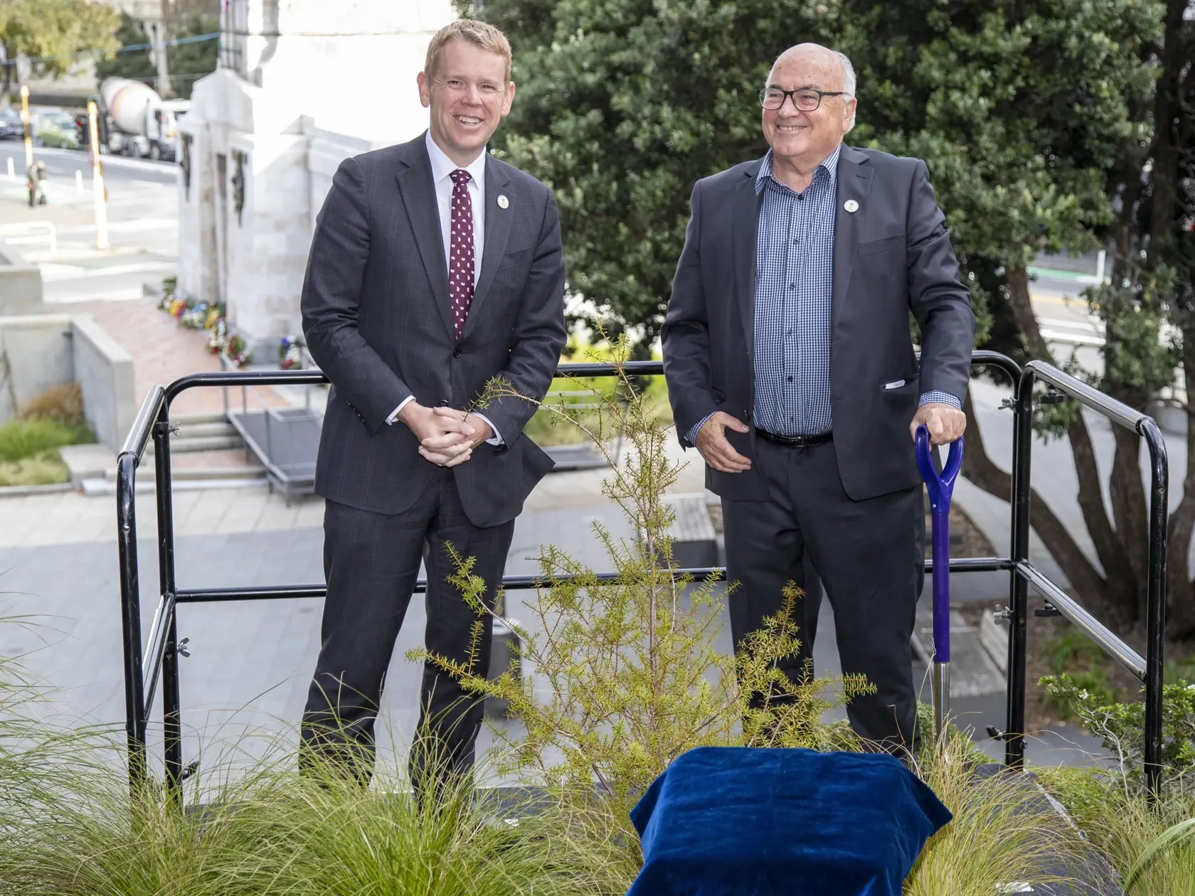 WA 9 Wellington - Novozélandský premiér Chris Hipkins (vľavo) pózuje po zasadení stromu zvaného nohoplod (v maorijčine totara, latinsky podocarpus) pri príležitosti blížiacej sa korunovácie britského kráľa Karola III. v areáli parlamentu vo Wellingtone v stredu 26. apríla 2023. Slávnostnou ceremóniou zasadenia nohoplodu sa začala kampaň, ktorej cieľom je vysadiť na území Nového Zélandu až 10.000 pôvodných stromov.  "Keďže kráľ Karol III. je zanietený environmentalista a záhradkár, zdalo sa nám v