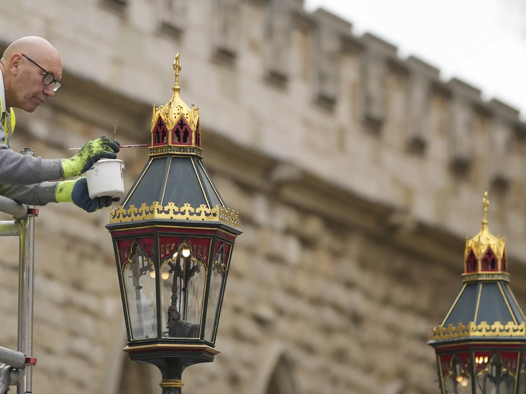 KK47 Londýn - Maliar premaľováva lampu pred Westminsterským opátstvom počas príprav na korunováciu britského kráľa Karola III. v Londýne 27. apríla 2023. Korunovácia Karola III. vo Westminsterskom opátstve sa bude konať 6. mája a zúčastnia sa na nej predstavitelia mnohých krajín sveta. FOTO TASR/AP
Painters repaint the lamp pots outside Westminster Abbey as preparations continue for the Coronation of King Charles III in London, Britain, Thursday, April 27, 2023. The Coronation of King Charles II