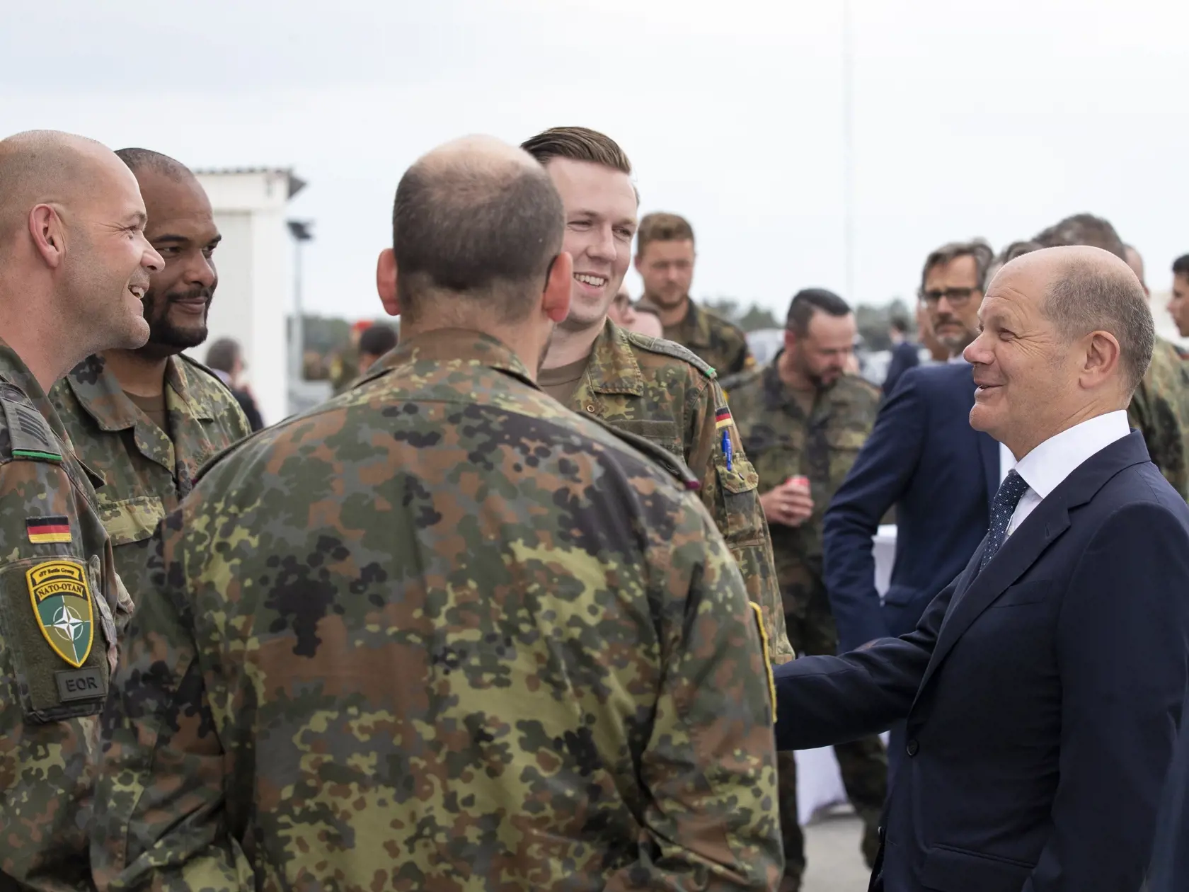 Nemecký kancelár Olaf Scholz (vpravo) a nemeckí vojaci, ktorí sú súčasťou prápora Severoatlantickej aliancie (NATO), sa rozprávajú počas návštevy výcvikového strediska v meste Pabrade, ktoré sa nachádza 60 km severne od litovskej metropoly Vilnius v utorok 7. júna 2022.