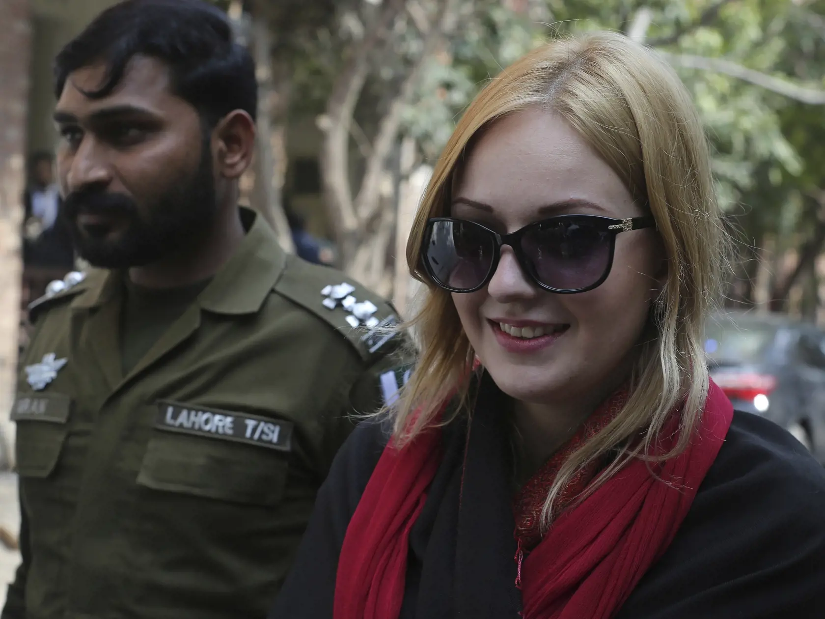 A Pakistani police officer escorts Tereza Hluskova, a Czech citizen, to a court in Lahore, Pakistan, Tuesday, Feb. 19, 2019. Hluskova was arrested last year on charges of attempting to smuggle heroin from Pakistan to Abu Dhabi. Since her arrest in 2018, she told investigators that she came to Pakistan to work as a model but that someone put narcotics into her luggage. (AP Photo/K.M. Chaudary)