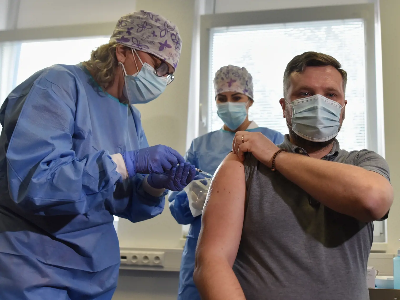 Na snímke vpravo riaditeľ Fakultnej nemocnice Trnava (FNTT) Vladislav Šrojta, ktorého zdravotná sestra očkuje proti ochoreniu COVID-19 vo Fakultnej nemocnici v Trnave v utorok 5. januára 2021. FOTO TASR – Lukáš Grinaj